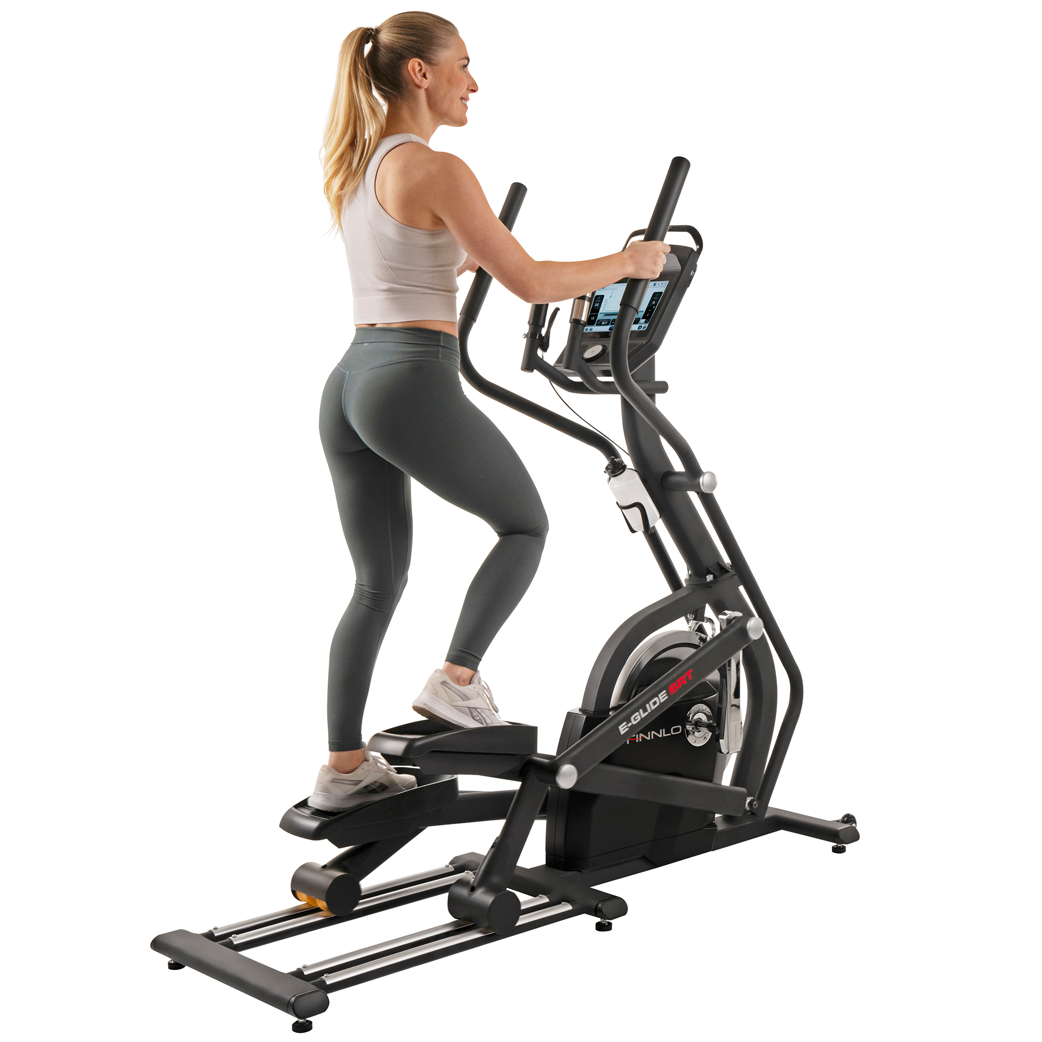 Eine Frau trainiert auf einem Crosstrainer. Sie trägt ein graues Oberteil und Leggings. Die Maschine ist schwarz, mit einem Bildschirm.