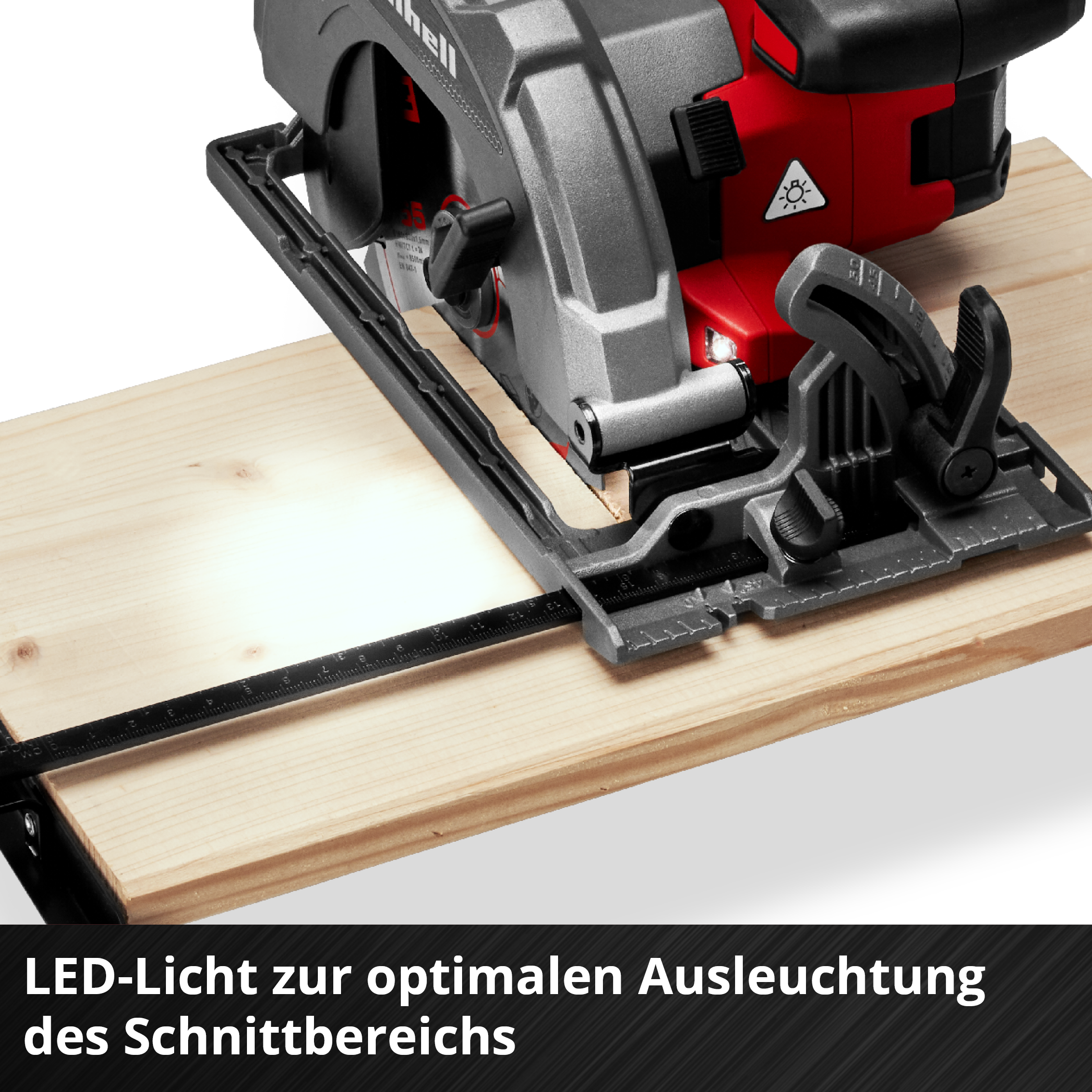 Eine Kreissäge mit rotem und grauem Gehäuse schneidet ein Holzbrett. Die Säge hat eine schwarze Basis und LED-Licht.