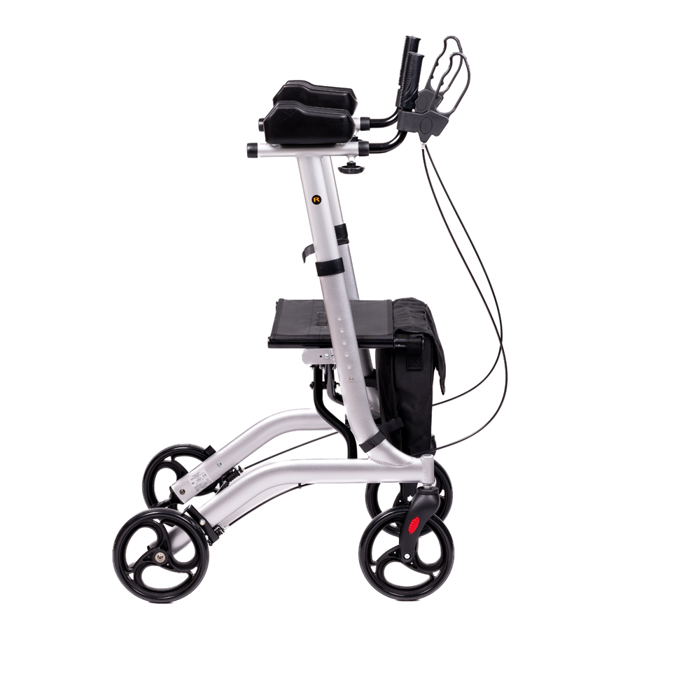 Ein silberner Rollator mit schwarzen Rädern, einem Sitz, Griffen und einer schwarzen Tasche, der zur Unterstützung der Mobilität dient, vor weißem Hintergrund.