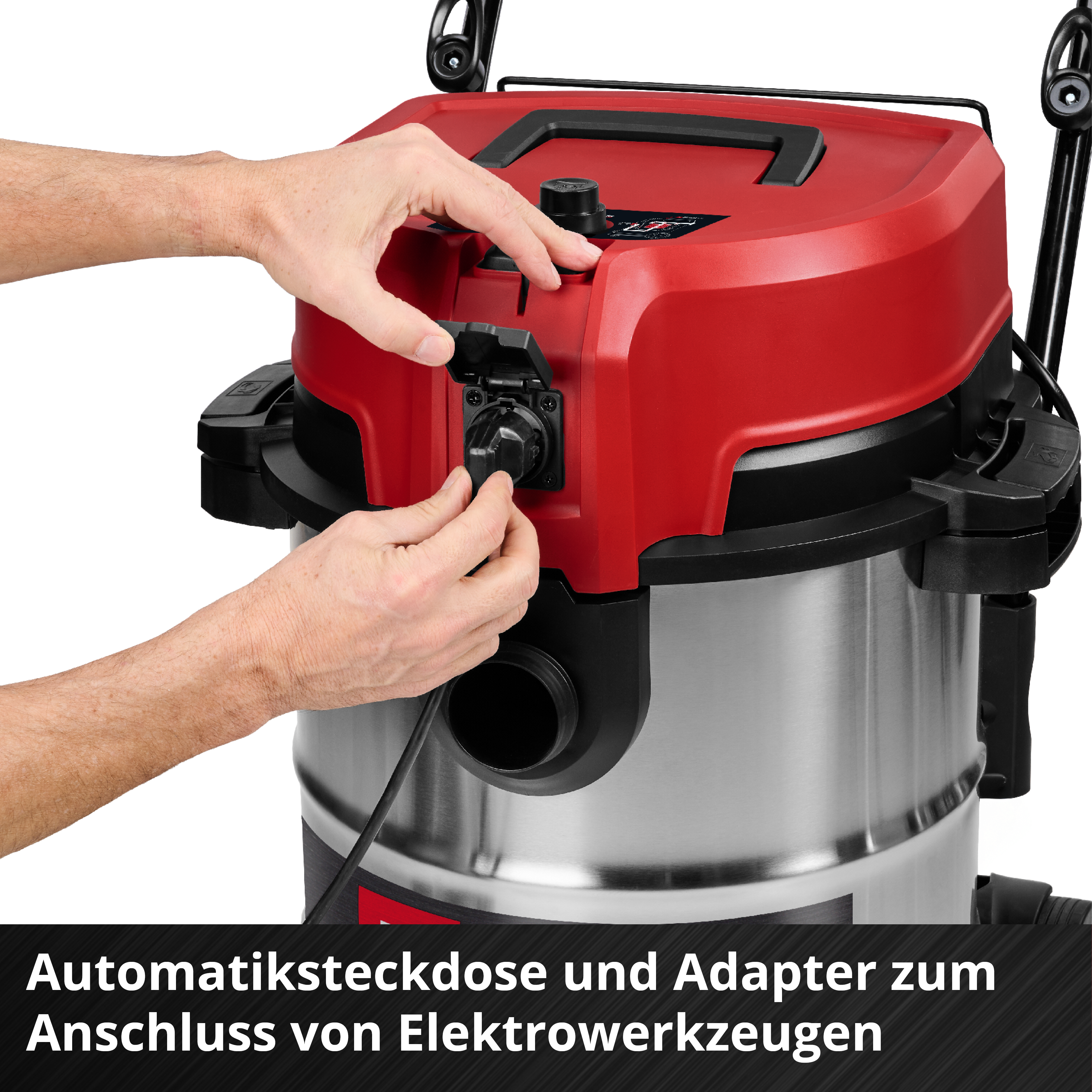 Eine Person verbindet ein Netzkabel mit einem rot-silbernen Staubsauger. Der Staubsauger hat einen schwarzen Griff und einen Anschluss.