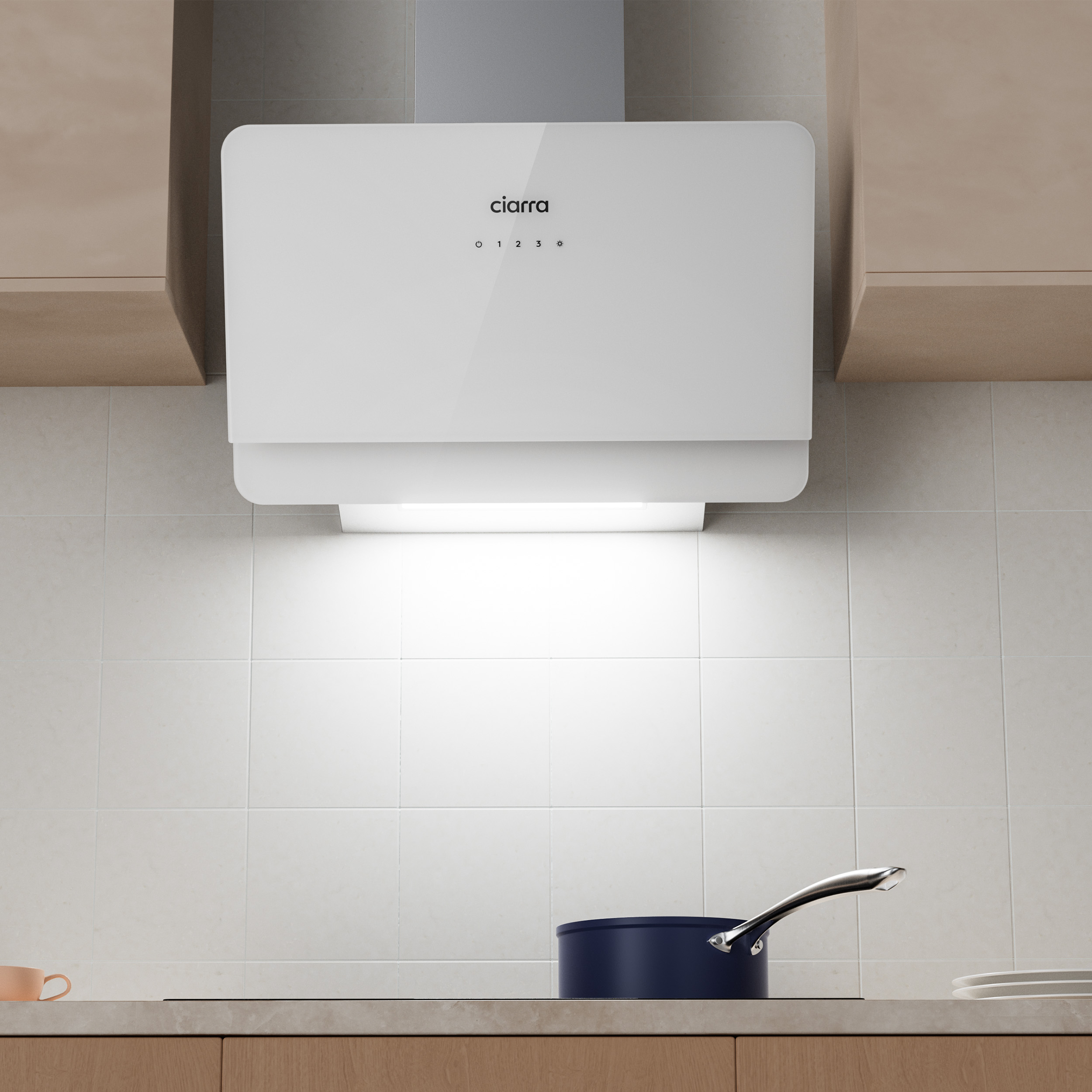 Een witte afzuigkap boven een fornuis met een donkerblauwe pan. Licht weerkaatst van het oppervlak. Beige kasten.
