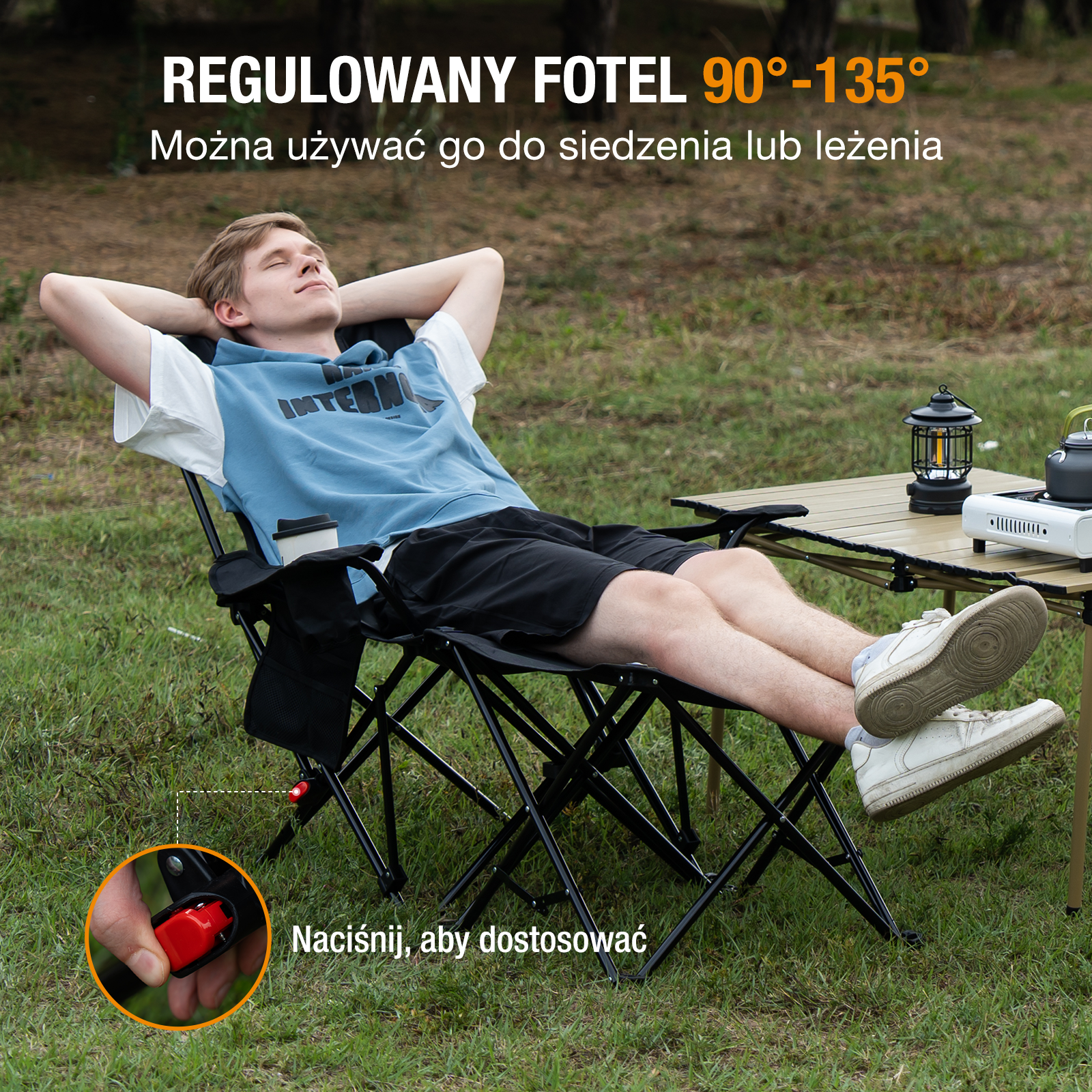 Mężczyzna relaksuje się na czarnym krześle składanym w parku. Mały stolik z lampą i kuchenką kempingową po prawej.