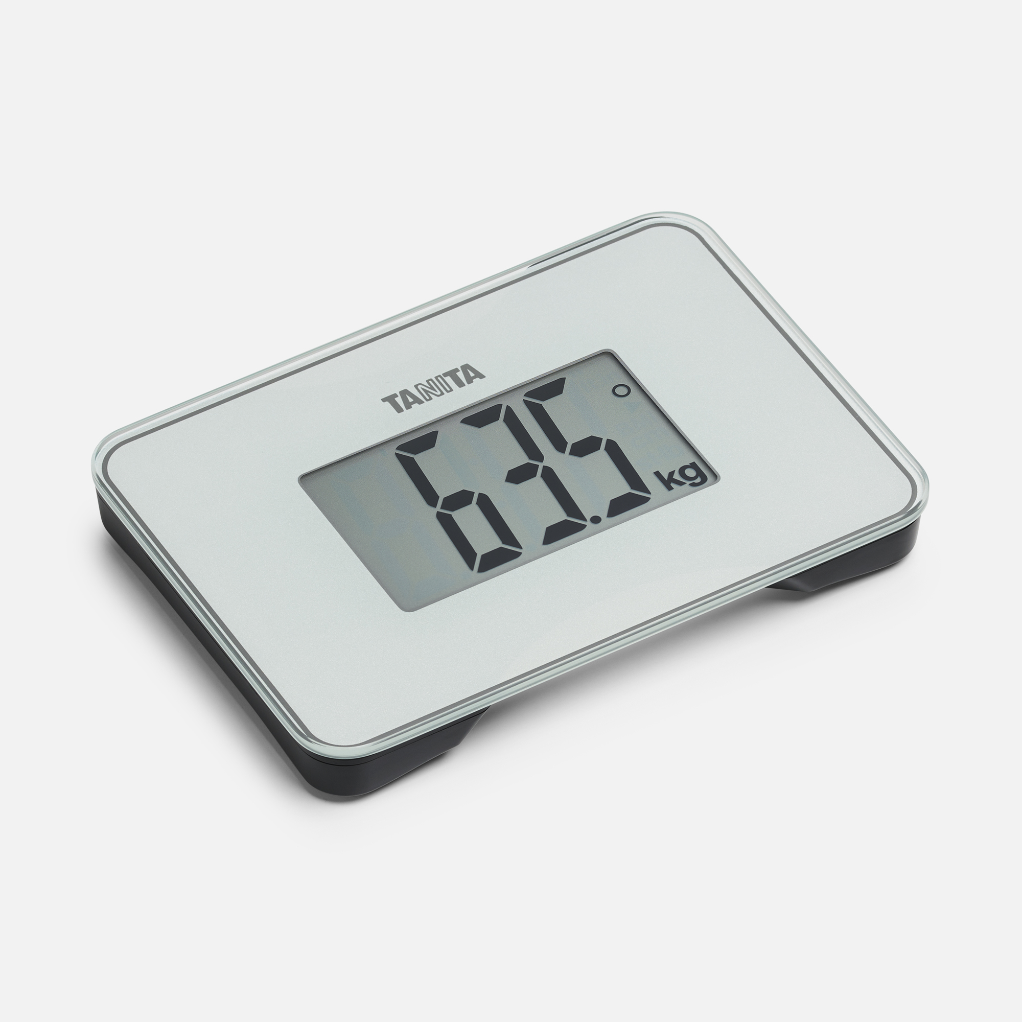Een digitale badkamerweegschaal met het merk 'Tanita'. Het scherm toont 63,5 kg. De weegschaal is wit met een zwarte basis.