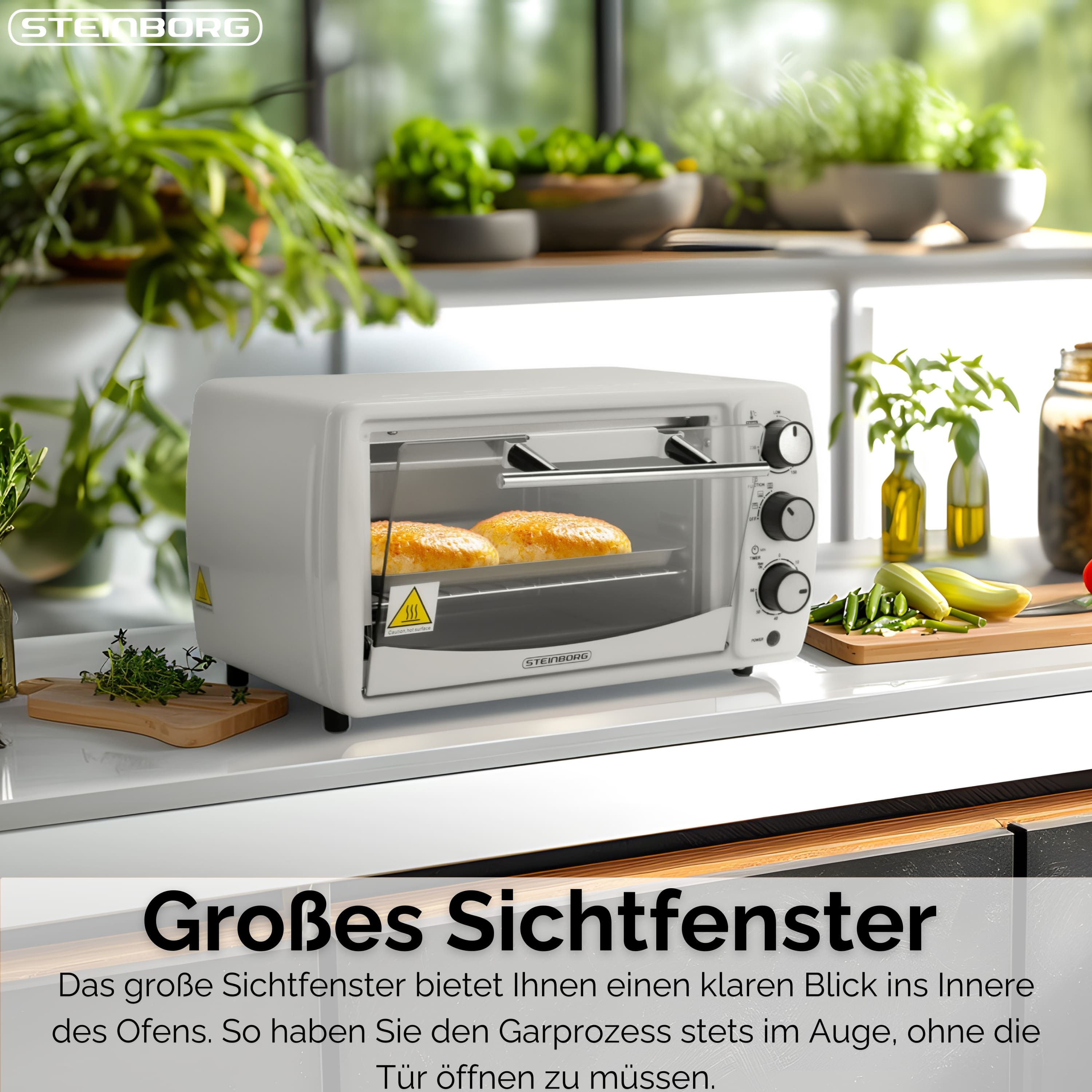 Ein weißer Toaster mit zwei gebackenen Brötchen. Gemüse und Kräuter liegen auf der Theke im Hintergrund.