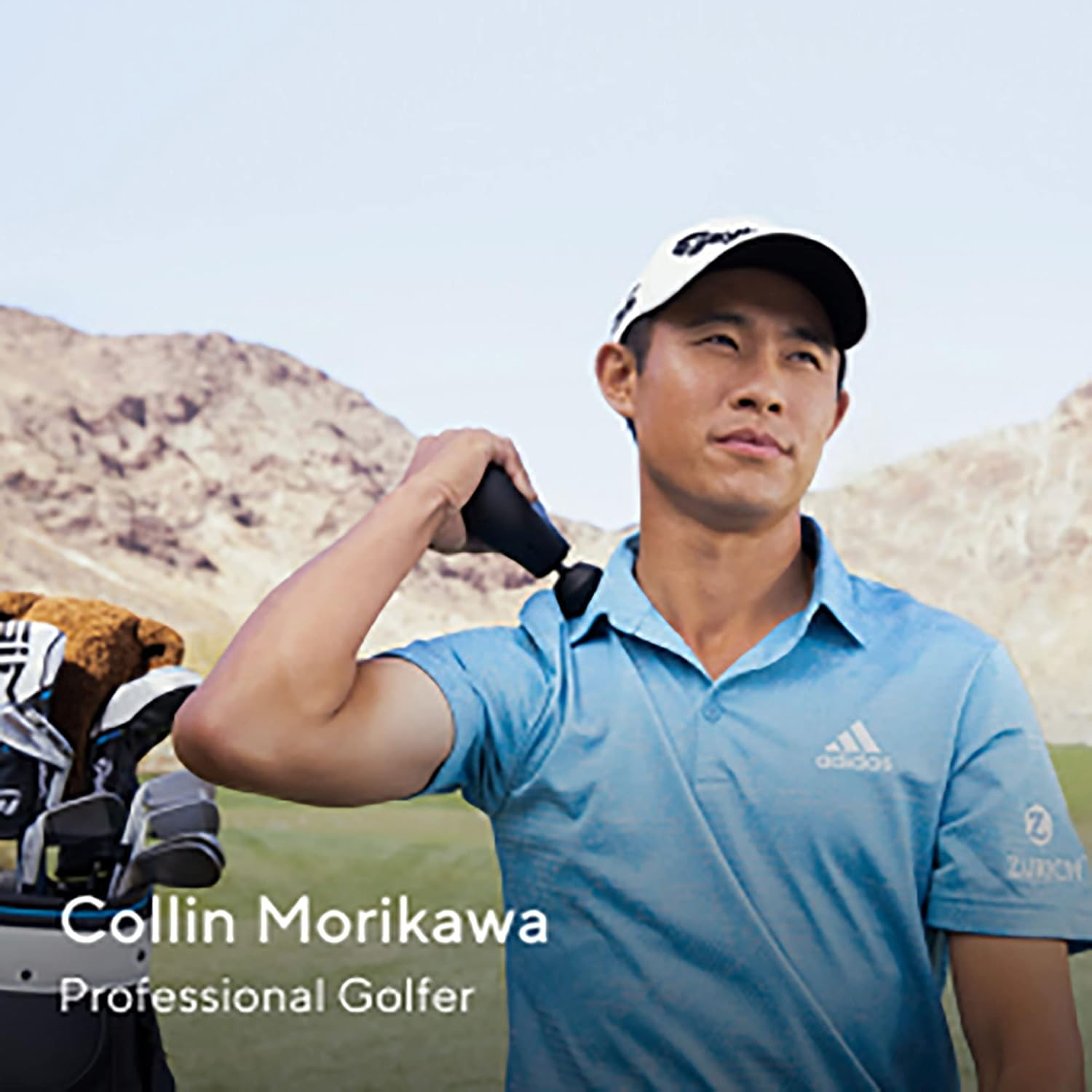 El golfista Collin Morikawa con una herramienta de masaje en el hombro, bolsa de golf a la izquierda, montañas al fondo.