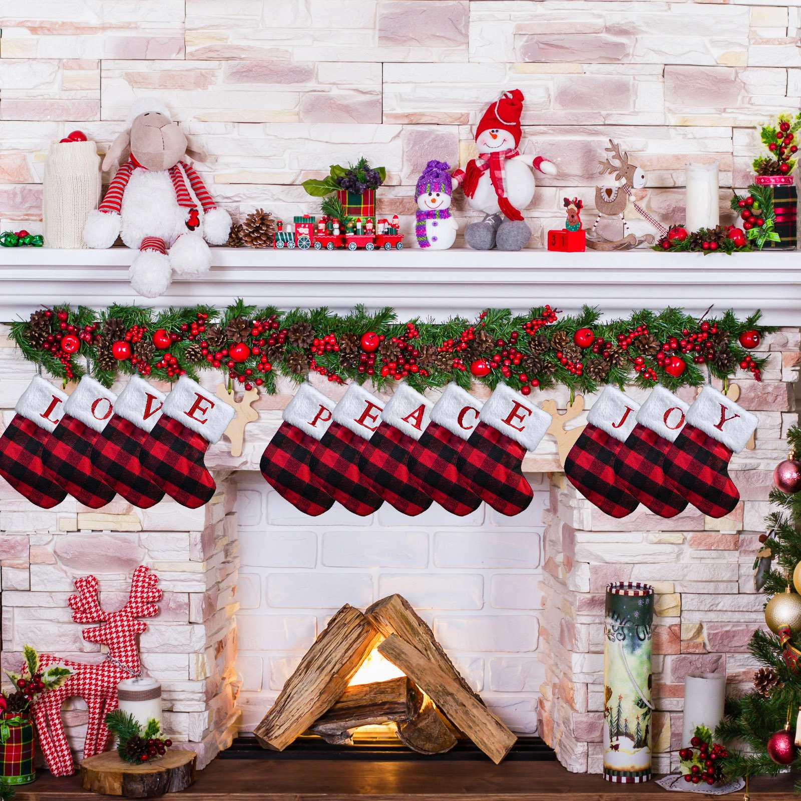Weihnachtsszene mit Kamin, Strümpfen, Ornamenten und Dekorationen. Kamin mit Holz, Strümpfe mit LOVE, PEACE, JOY.