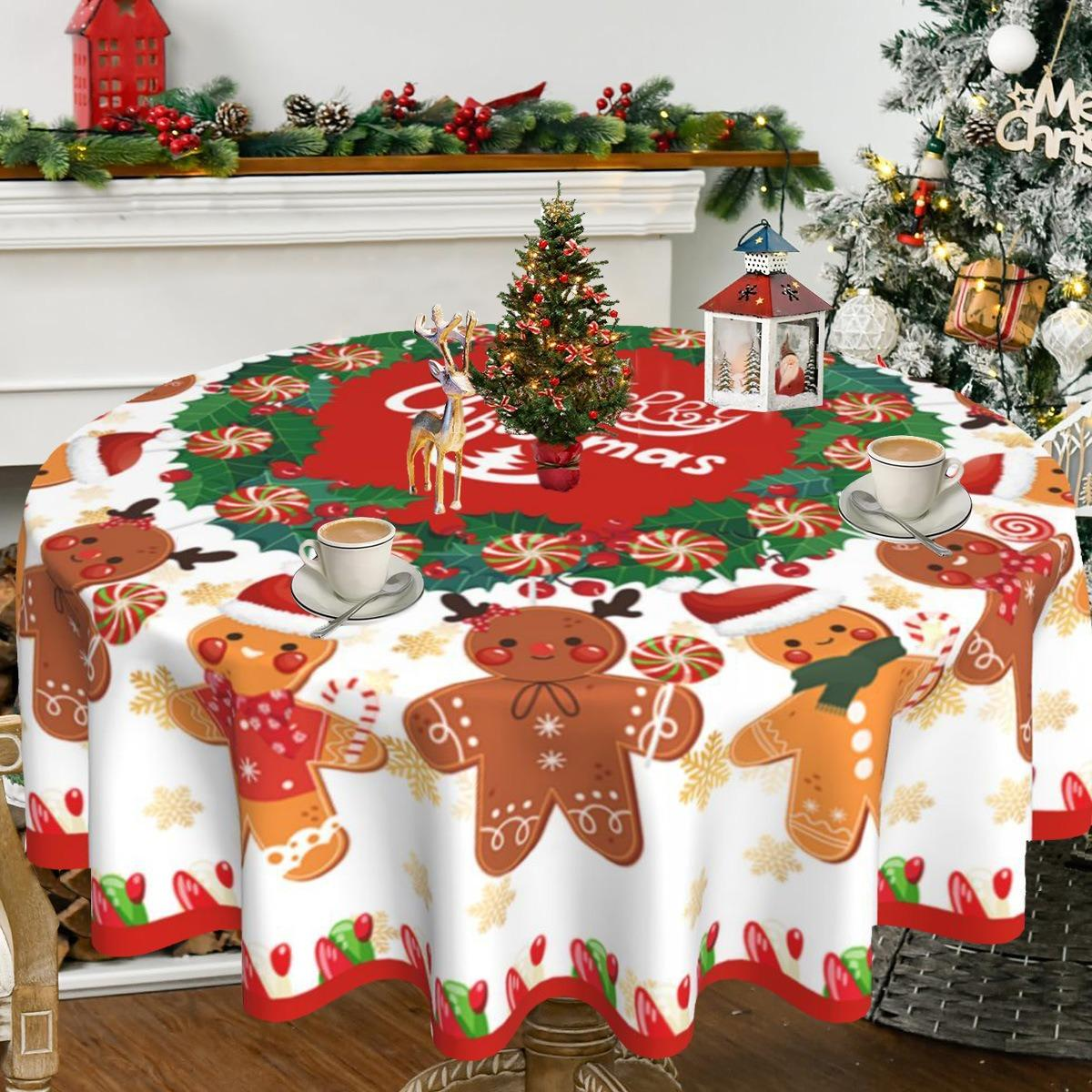 Weihnachtstisch. Tischdecke mit Lebkuchenmännern, Zuckerstangen und kleinem Weihnachtsbaum. Kaffeetassen auf dem Tisch.