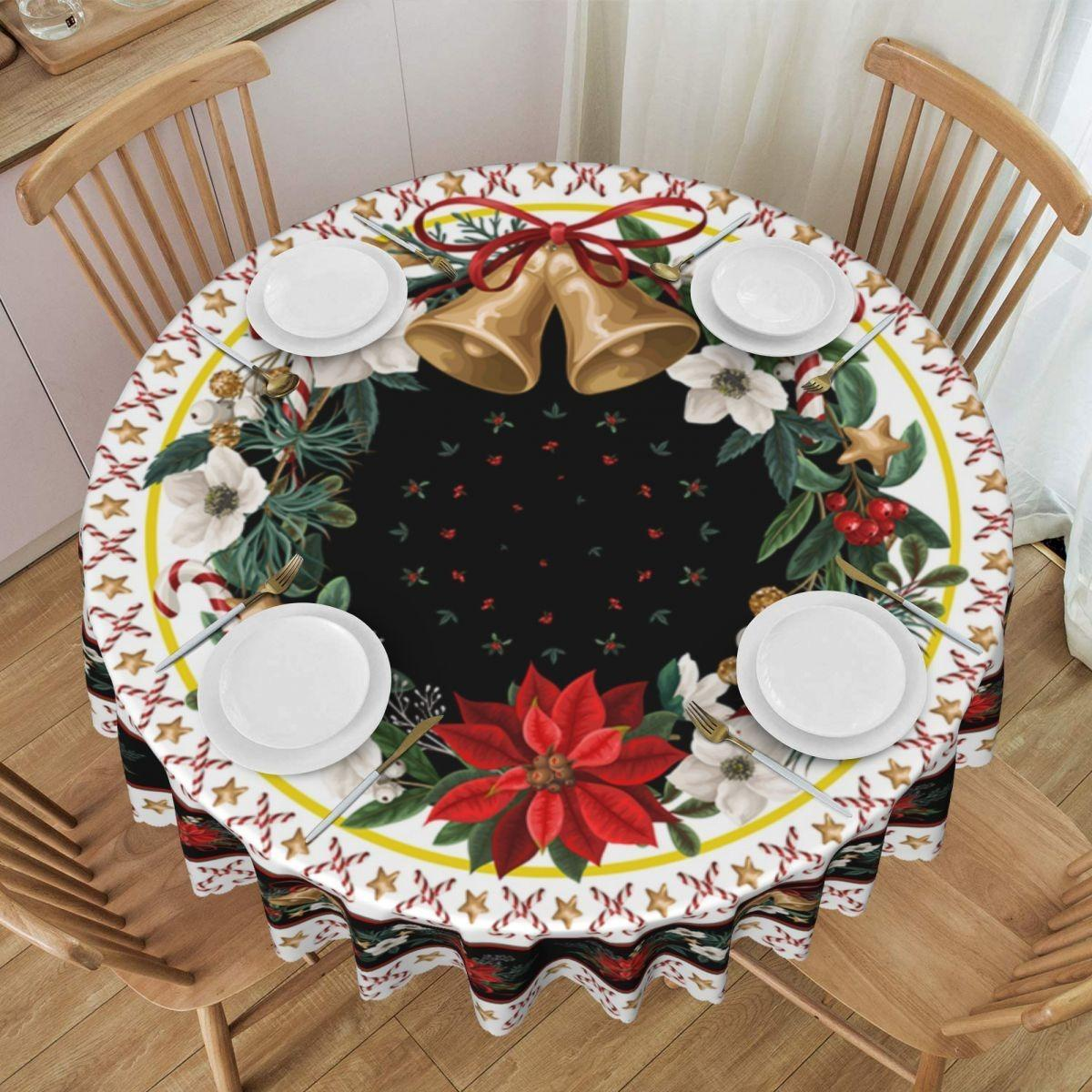 Ein runder Tisch für Weihnachten, mit Tellern, Besteck und einer festlichen Tischdecke mit Glocken, Blumen und einem Weihnachtsstern.