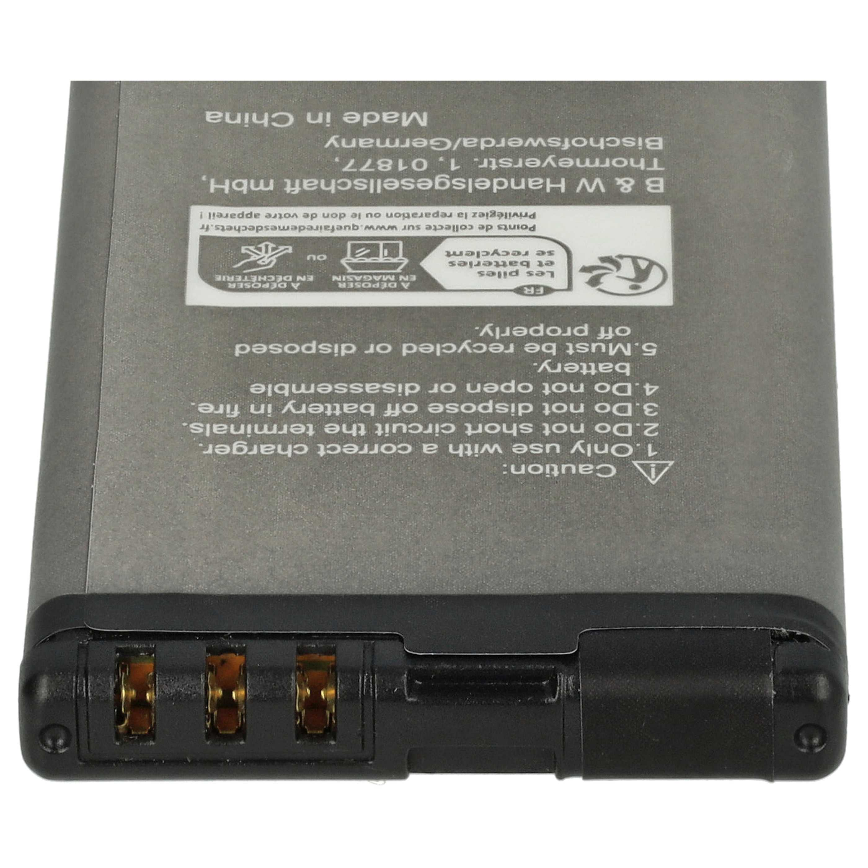 Akku mit Warnhinweisen und Anweisungen auf grauem Untergrund. Schwarzer Stecker unten, Text in Englisch und Französisch.