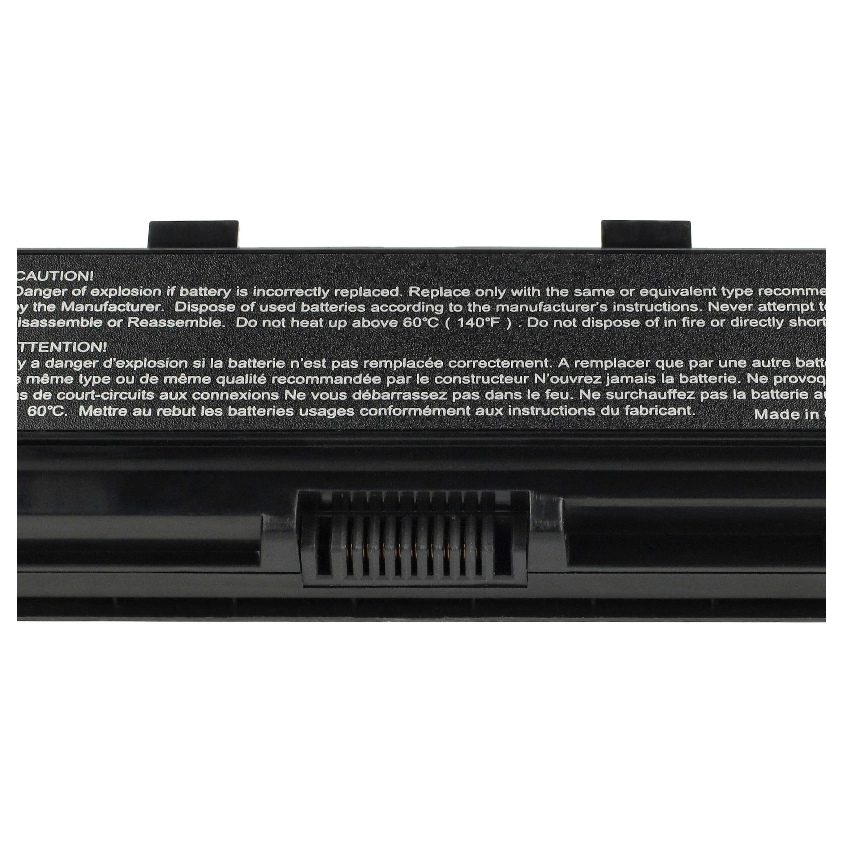 Nahaufnahme eines schwarzen Laptop-Akkus mit Warnhinweisen. Stecker und Warnschilder sind sichtbar.