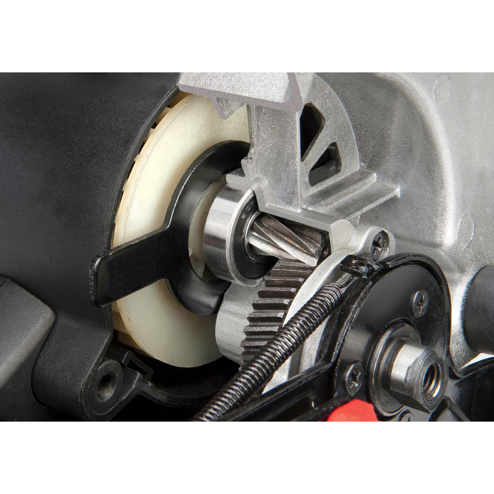 Close-up van interne componenten van een motor. Tandwielen, lagers en een veer zijn zichtbaar. De materialen zijn metaal, zwart plastic en wit.