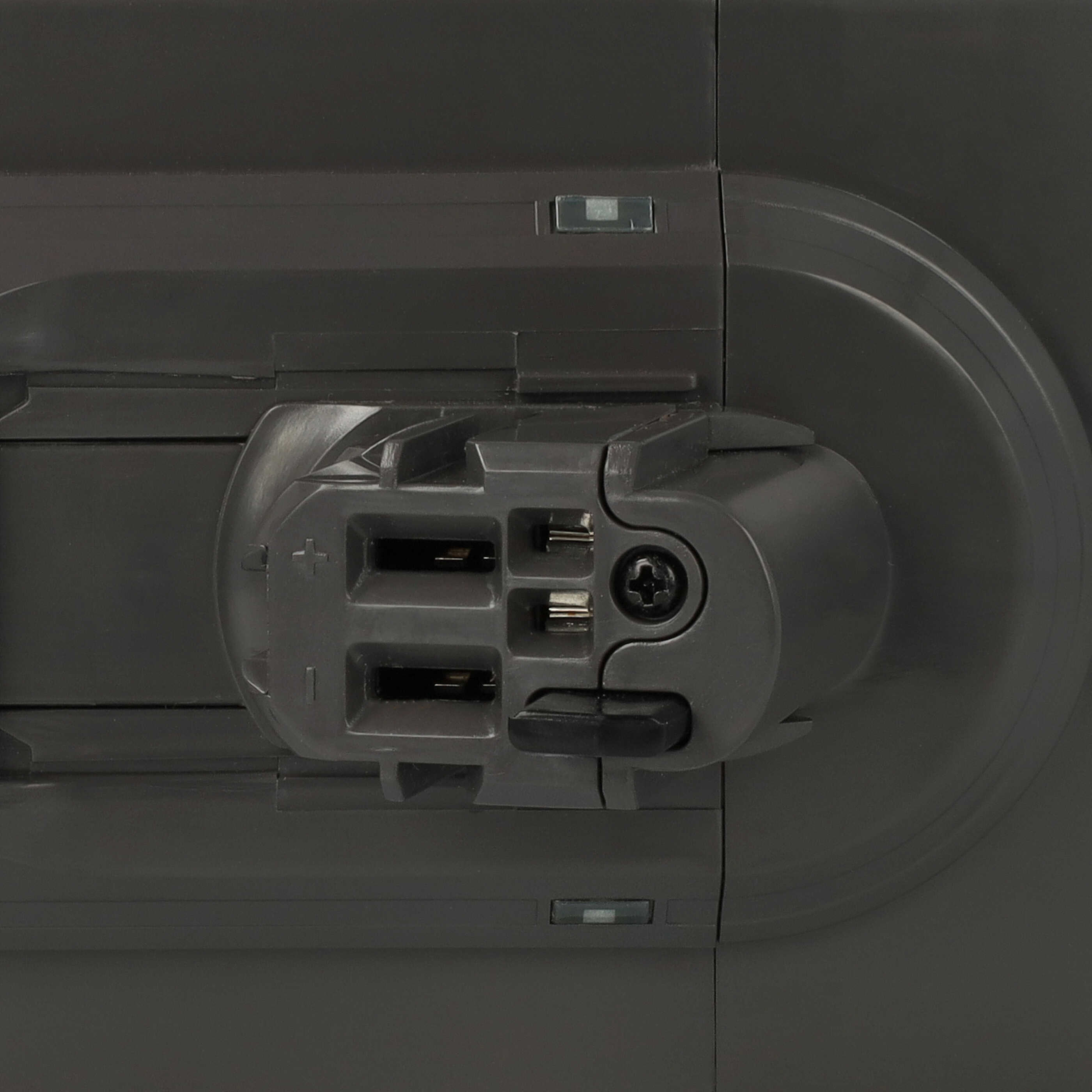 Nahaufnahme eines dunkelgrauen Geräts mit Stecker. Merkmale sind ein zentraler Anschluss, Schrauben und Kontrollleuchten.
