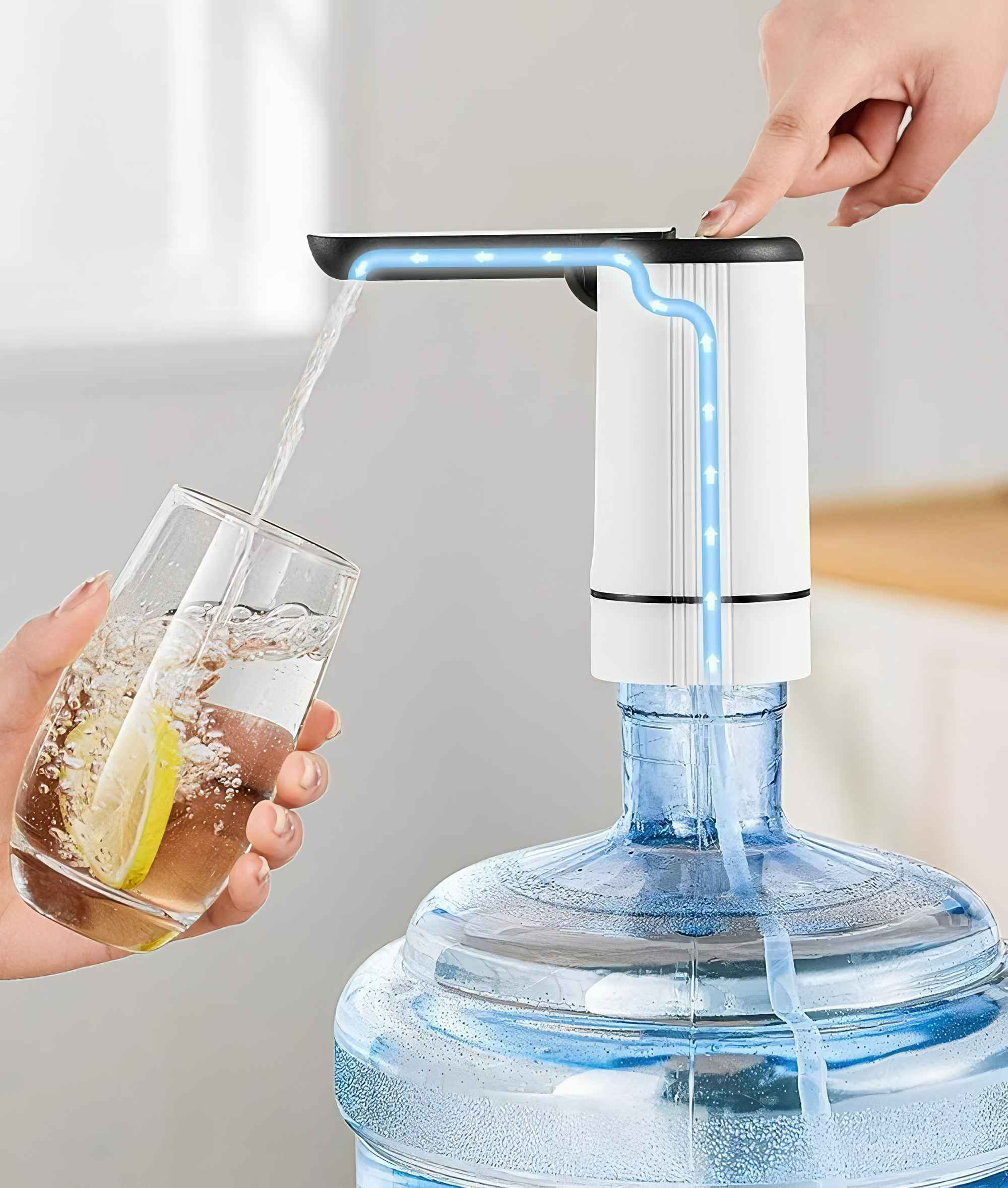 Eine Hand drückt einen Wasserspender. Wasser fließt in ein Glas mit einer Zitronenscheibe, das auf einer Wasserflasche steht.