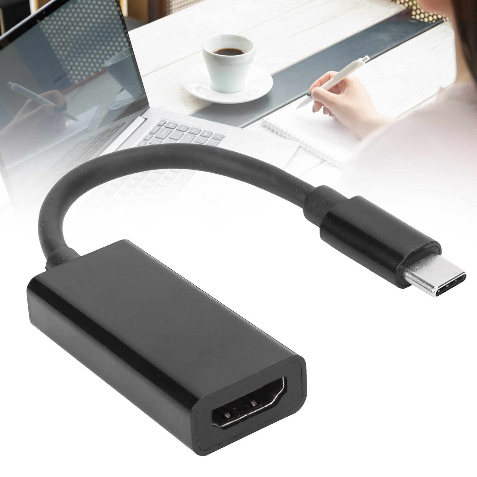 Schwarzer HDMI-zu-USB-C-Adapter. Eine Person schreibt auf Papier. Ein Laptop und eine Kaffeetasse sind im Hintergrund.
