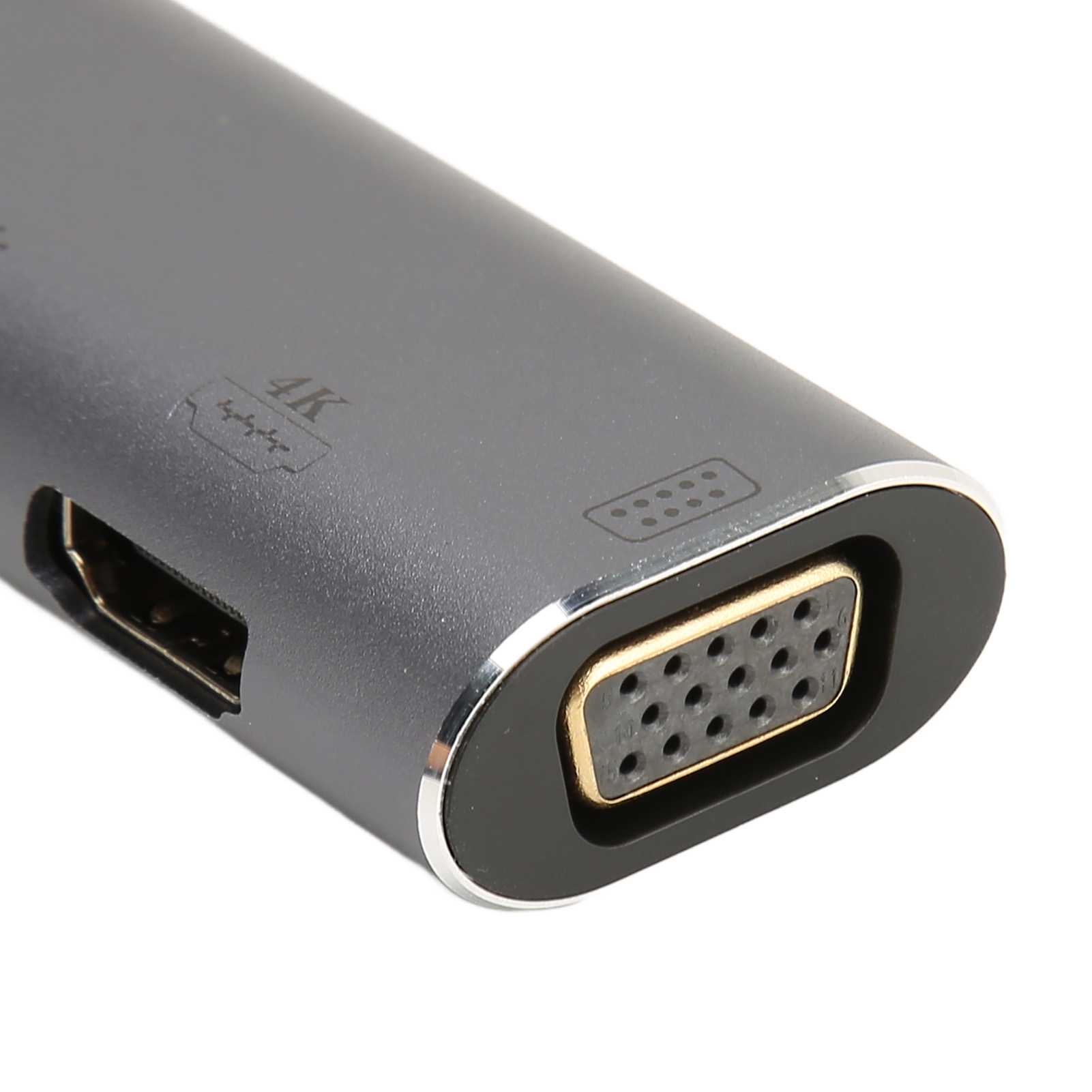 Nahaufnahme eines grauen Multiport-Adapters. Er hat einen VGA-Anschluss, einen HDMI-Anschluss und eine 4K-Beschriftung.
