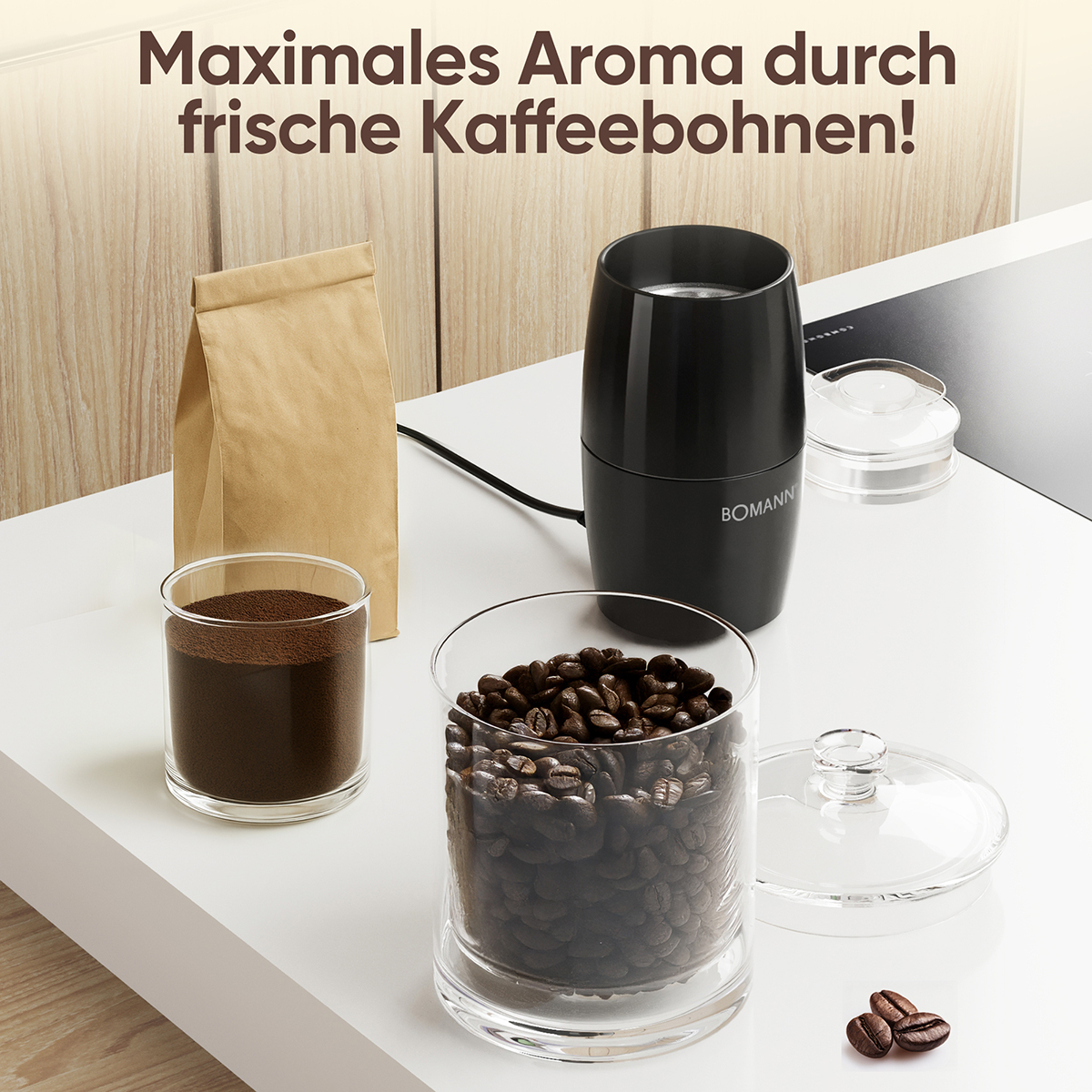 Kaffeebohnen, gemahlener Kaffee, eine Kaffeemühle und ein Beutel Kaffeebohnen stehen auf einer weißen Oberfläche. Die Szene ist gut beleuchtet.