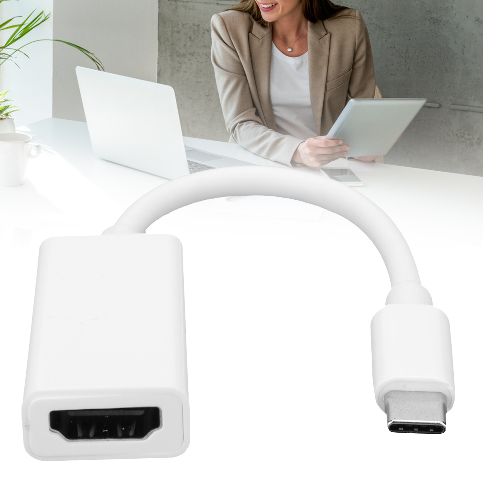 Weißer HDMI-zu-USB-C-Adapter, Frau hält im Hintergrund ein Tablet, Laptop und eine Pflanze auf einem weißen Tisch.