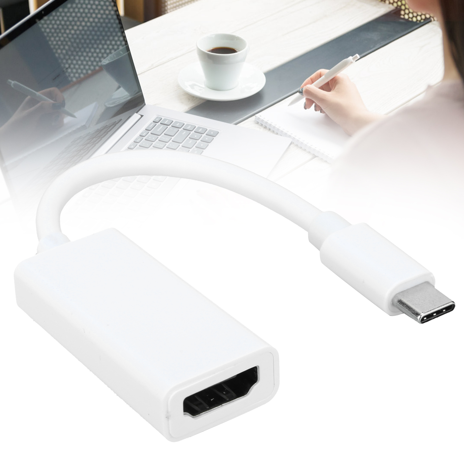 Weißer HDMI-Adapter, verbunden mit Laptop und Person beim Schreiben. Tasse Kaffee daneben. Szene auf einem Tisch.
