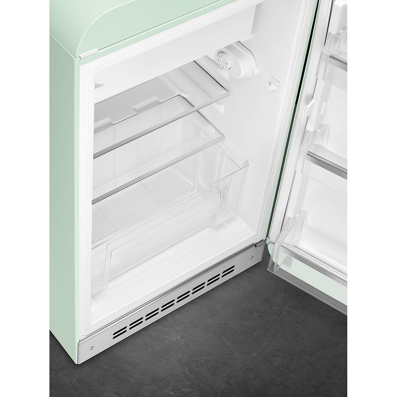 Refrigerador verde menta abierto con estantes y cajones transparentes, interior iluminado. Suelo oscuro.