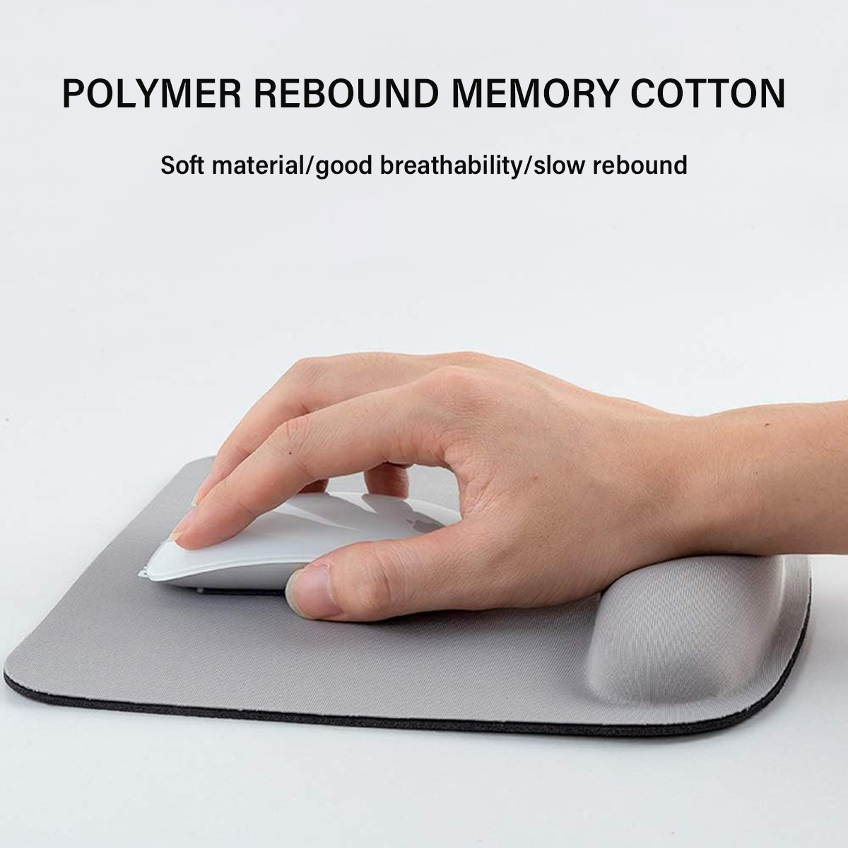 Eine Hand benutzt eine weiße Maus auf einem grauen Mauspads mit Handgelenkstütze. Text oben: POLYMER REBOUND MEMORY COTTON.
