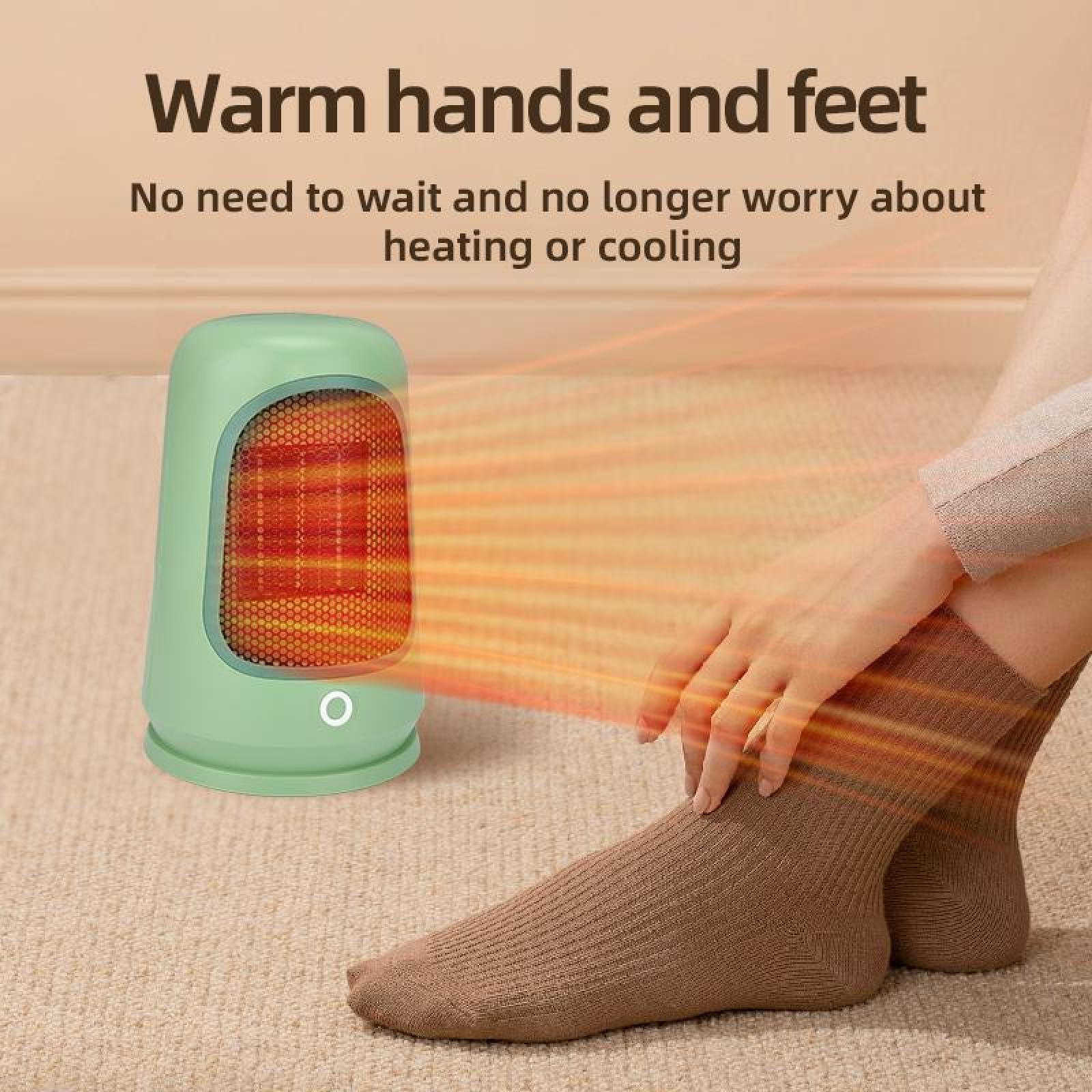 Ein grüner Heizlüfter mit orangefarbenem Innenraum wärmt Hände und Füße. Eine Person trägt Socken und sitzt auf einem Teppich.