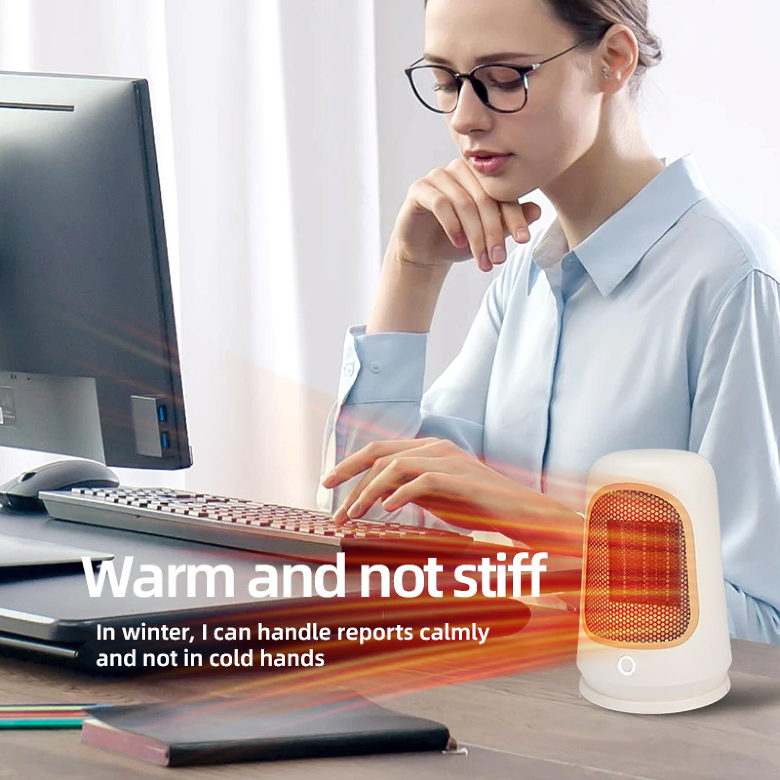 Eine Frau mit Brille arbeitet am Computer. Ein kleiner weißer Heizlüfter steht auf dem Schreibtisch. Text: Warm und nicht steif.