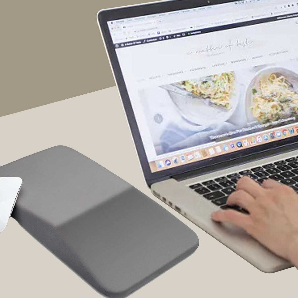 Ein Laptop ist geöffnet und zeigt eine Website mit Essensbildern. Eine Hand tippt auf der Tastatur. Ein graues Mauspad und eine Maus sind sichtbar.
