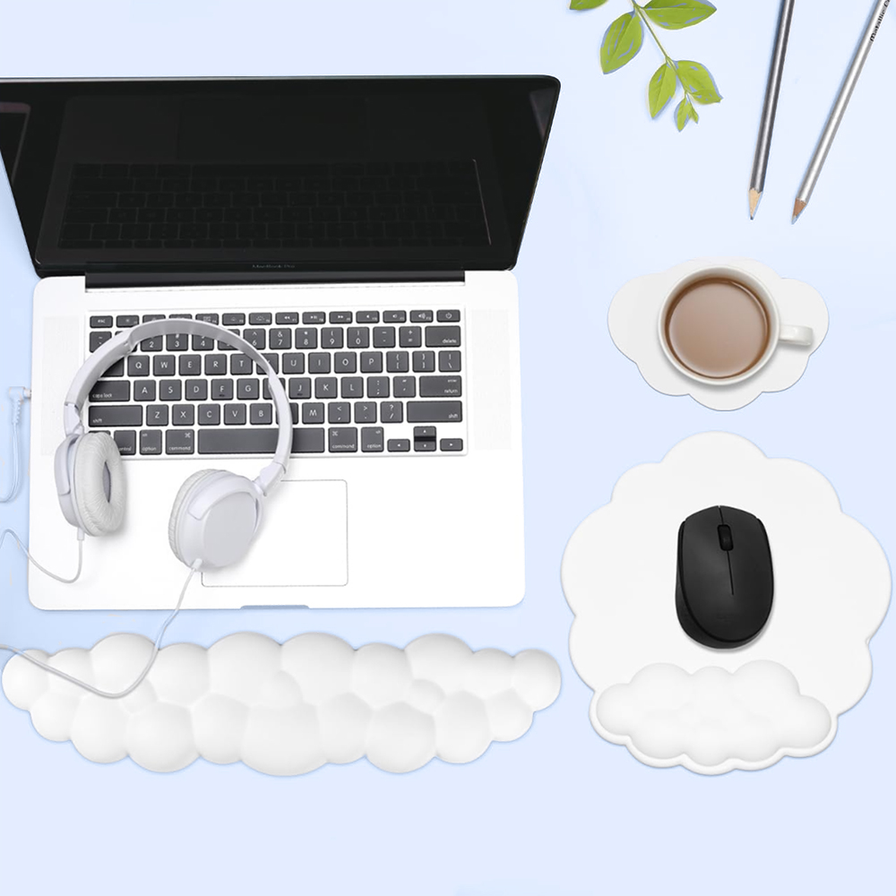 Laptop mit weißen Kopfhörern, Kaffeetasse, Maus und Bleistiften. Alles liegt auf einem hellblauen Schreibtisch. Der Schreibtisch hat wolkenförmige Mauspads.