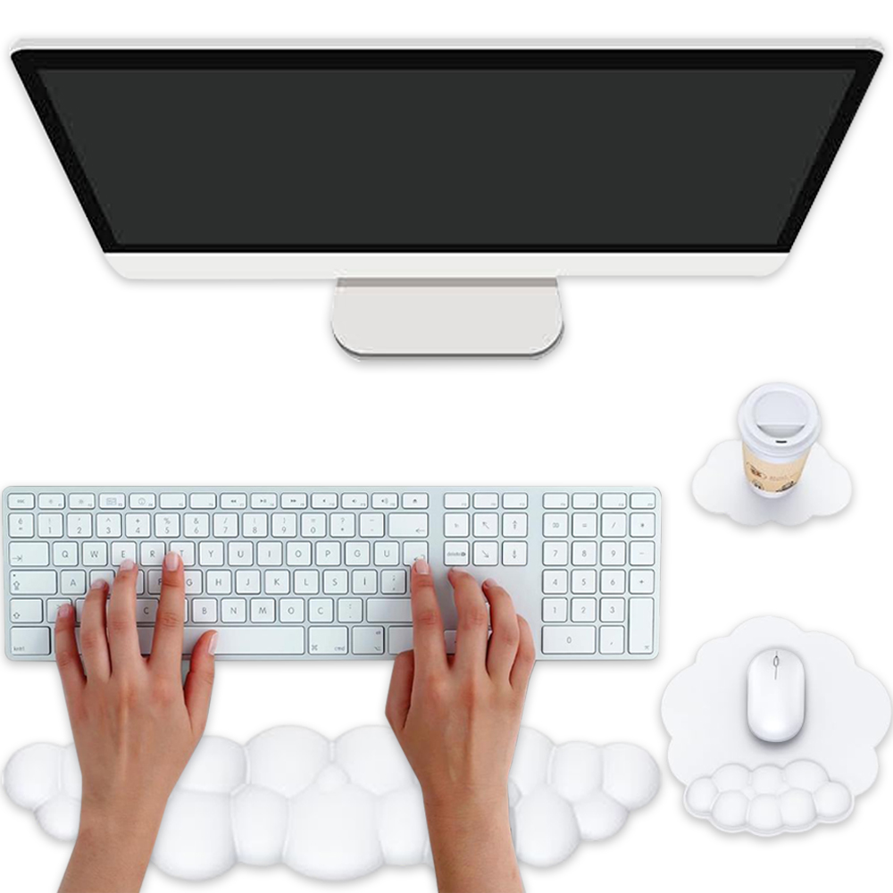 Ein Computer-Setup mit Händen, die auf einer Tastatur tippen, einem Bildschirm, einer Kaffeetasse, einer Maus und wolkenförmigem Zubehör.