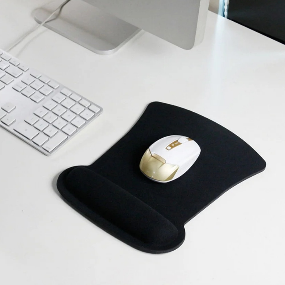 Eine weiße Maus mit goldenen Akzenten liegt auf einem schwarzen Mousepad mit Handgelenkauflage. Links befindet sich eine weiße Tastatur.