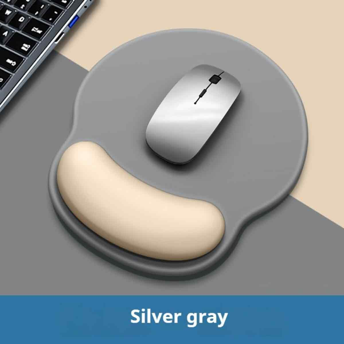 Eine silberne Maus und eine beige Handgelenkauflage auf einem grauen Mauspadd. Eine Tastatur ist teilweise sichtbar.