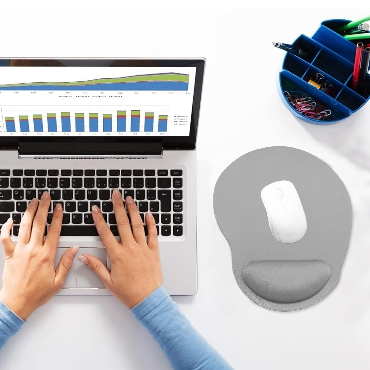 Person tippt auf Laptop. Weiße Maus auf grauem Mauspad. Blauer Schreibtisch-Organizer mit Stiften. Weißer Hintergrund mit Diagramm auf dem Bildschirm.