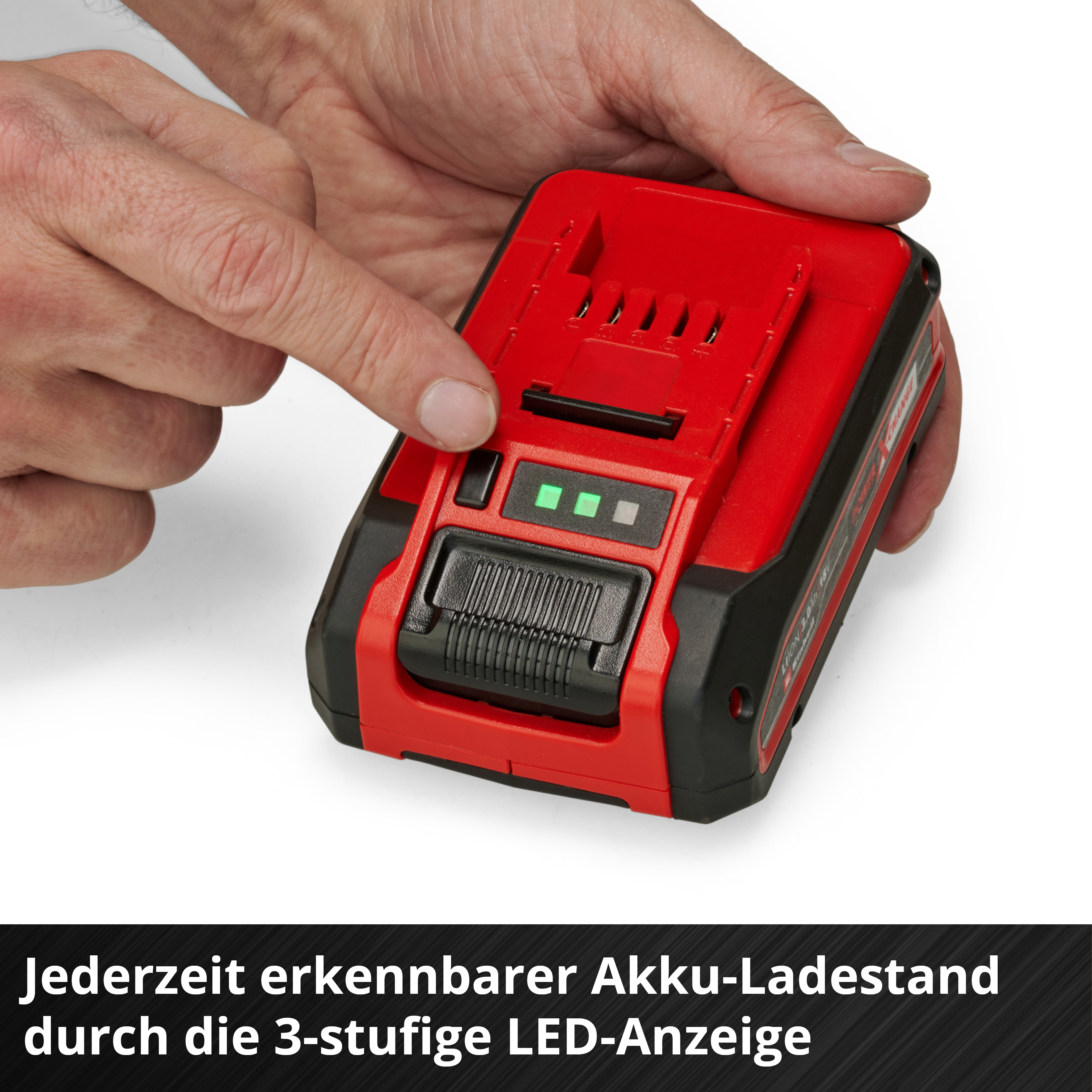 Roter Akku, von Händen gehalten. Finger zeigt auf grüne LEDs, die den Ladestand anzeigen.
