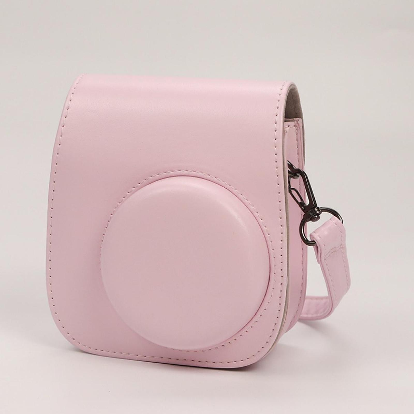 Eine rosa Kameratasche mit Schultergurt. Die Tasche ist abgerundet mit einer kreisförmigen Vorderseite. Auf weißem Untergrund.
