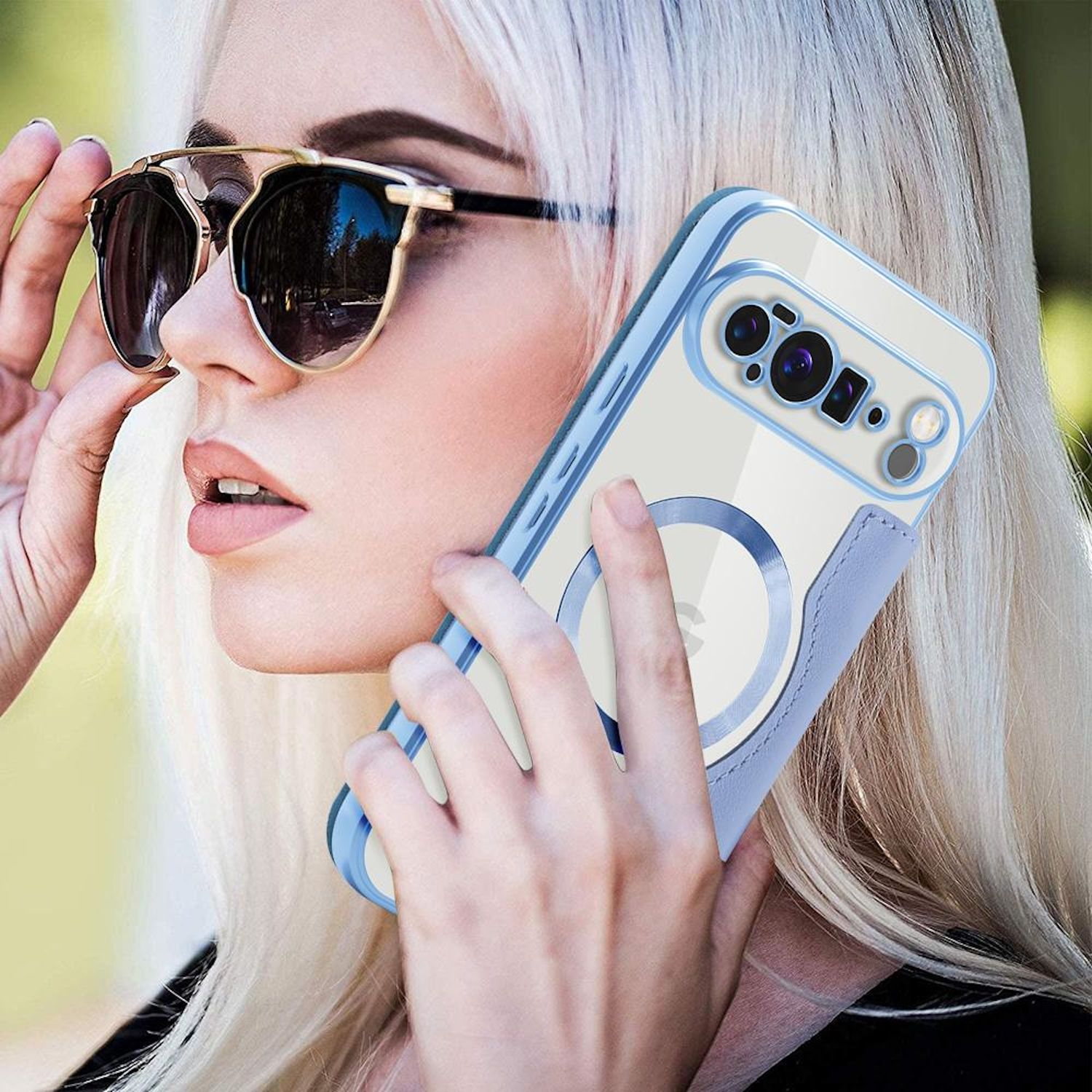 Blonde Frau hält Telefon mit Sonnenbrille. Telefonhülle hat blaue Ränder und einen blauen Ring. Sie ist draußen.