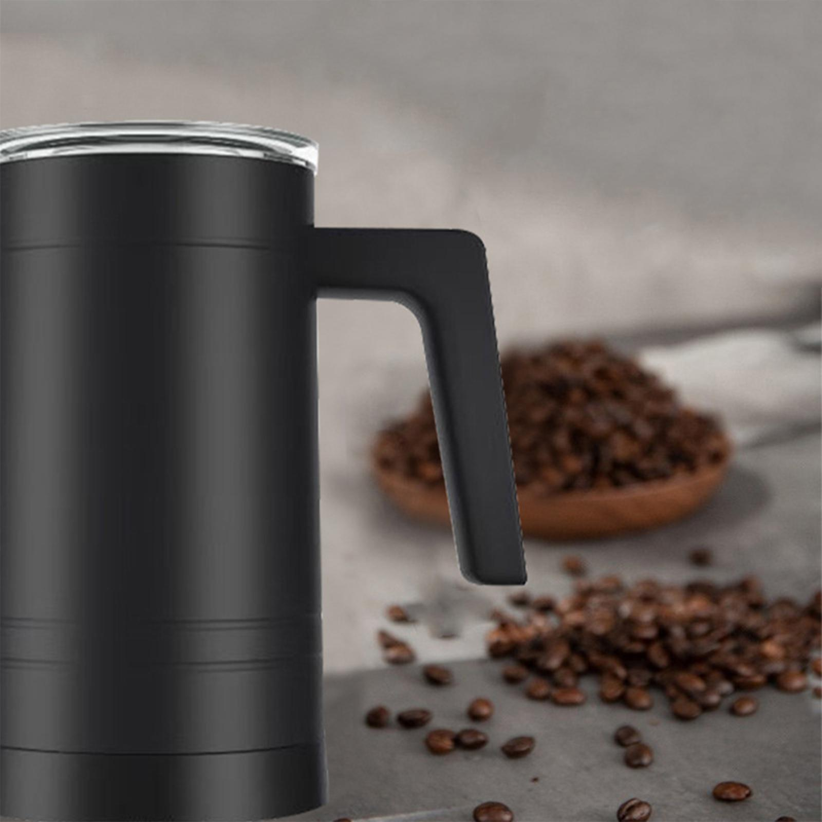 Schwarzer Becher mit Henkel auf einem Tisch. Kaffeebohnen in einer Holzschale und verstreut.