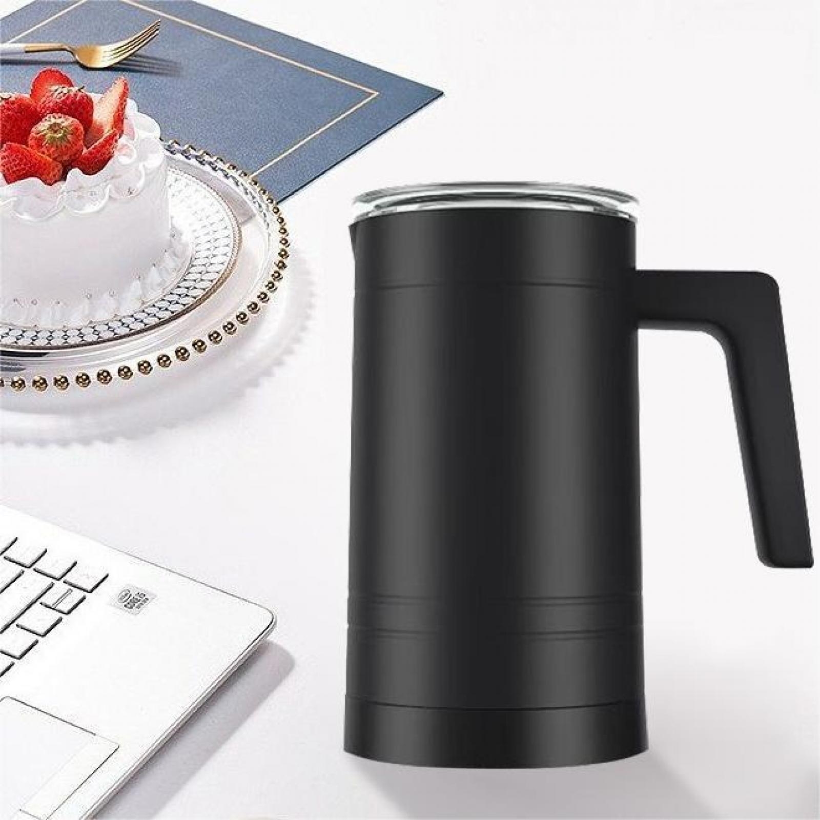 Ein schwarzer Becher mit Henkel steht neben einem Kuchen mit Erdbeeren, einem Laptop und einer Gabel auf weißem Untergrund.
