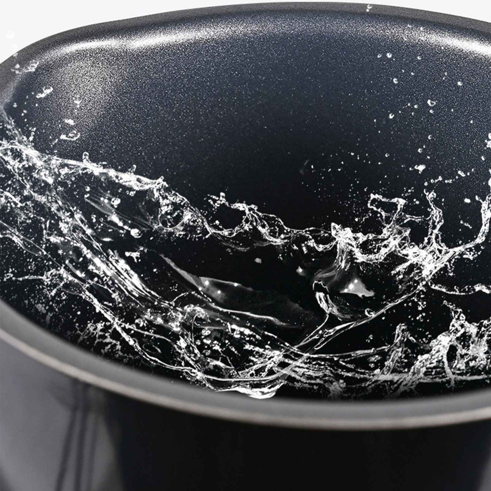 Nahaufnahme von Wasser, das in einer schwarzen Schüssel spritzt. Wassertropfen und -spritzer erzeugen dynamische Muster.