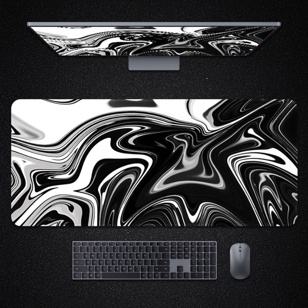 Computer-Setup: Monitor, Mousepad mit schwarz-weißem Wirbeldesign, Tastatur und Maus auf dunkler Oberfläche.