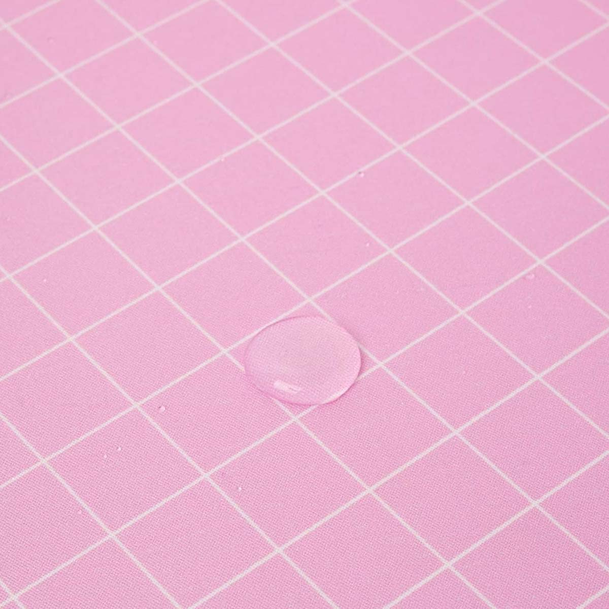 Gros plan d'une surface rose à motif quadrillé avec une goutte d'eau au centre. Lignes de quadrillage blanches et fond rose.