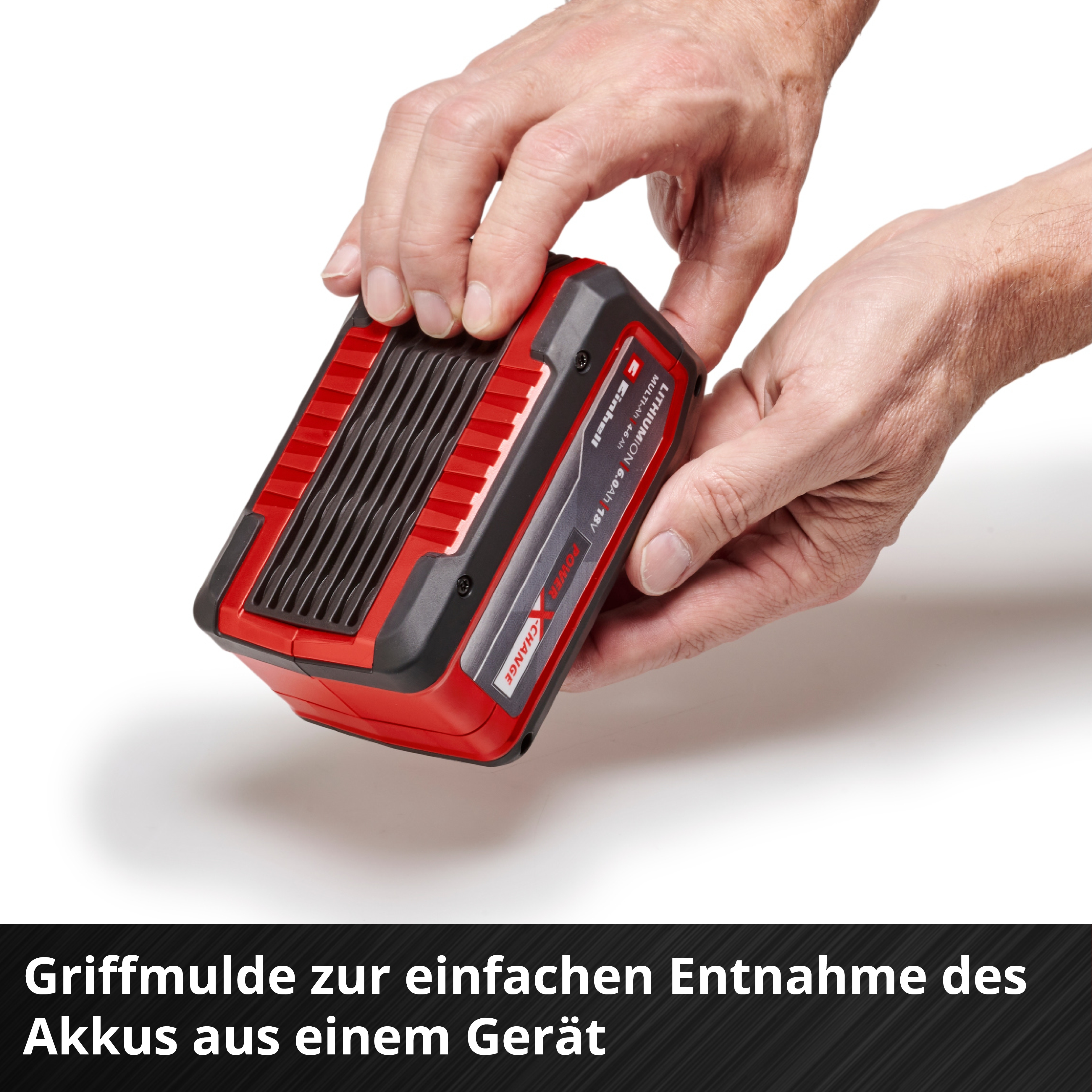 Mani che tengono un pacco batteria rosso e nero. Il pacco è etichettato Einhell Lithium-Ion 6.0Ah 18V.