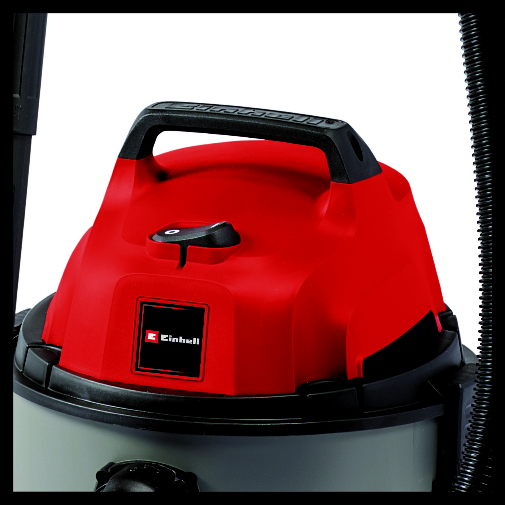 Primo piano di un aspirapolvere rosso. Maniglia nera, interruttore e logo Einhell visibili. Il tubo è nero.