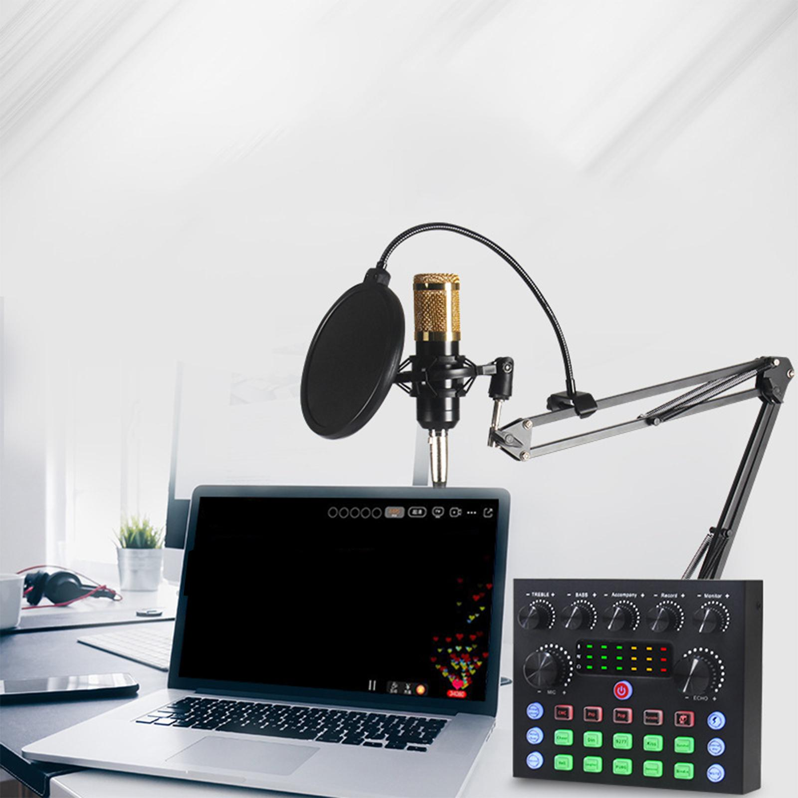 Ein Mikrofon mit Pop-Filter, Laptop und Audiomixer stehen auf einem weißen Schreibtisch. Der Laptop zeigt einen schwarzen Bildschirm.