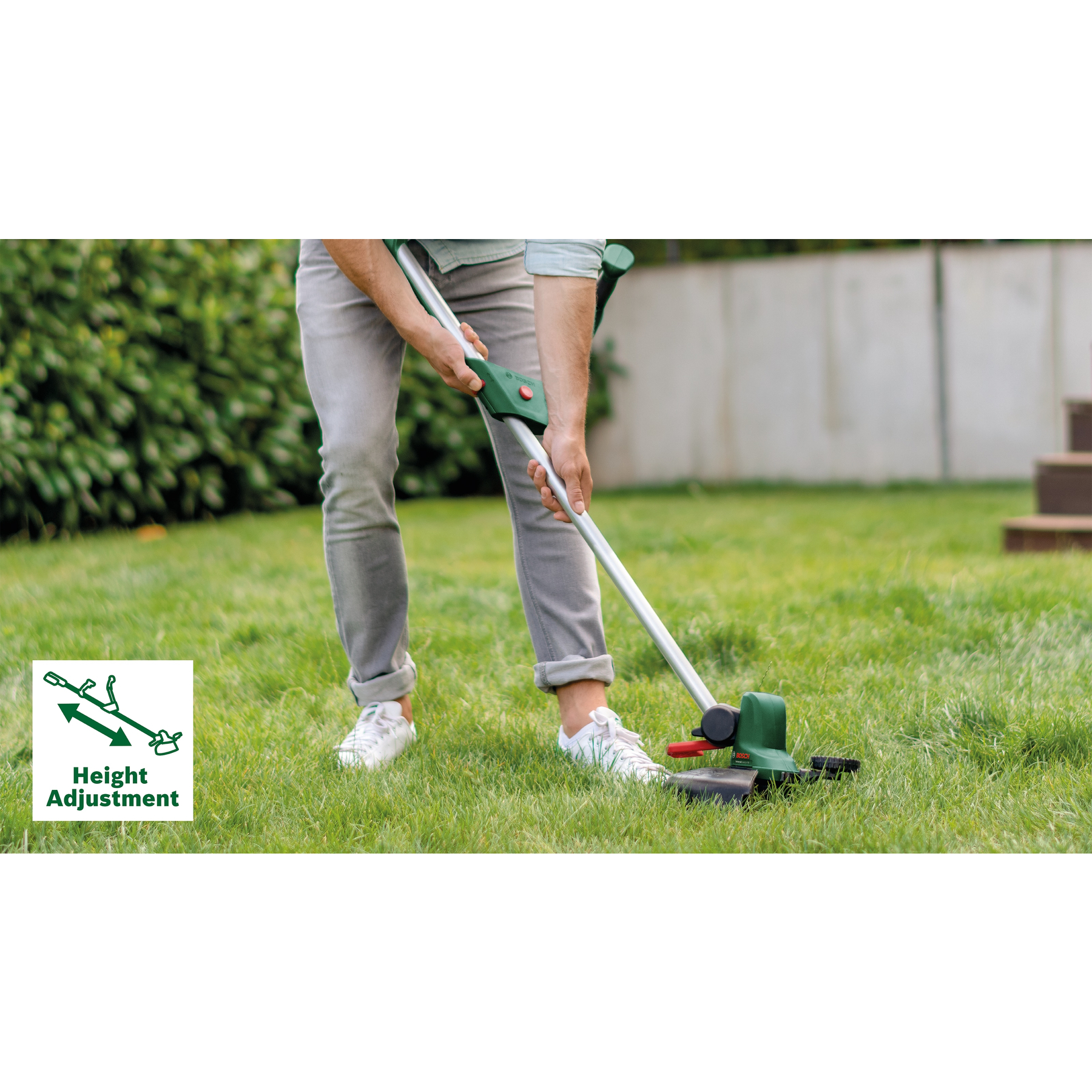 Eine Person benutzt einen grünen und schwarzen Rasenkantenmäher auf Gras. Das Werkzeug ist mit 'Höhenverstellung' gekennzeichnet.