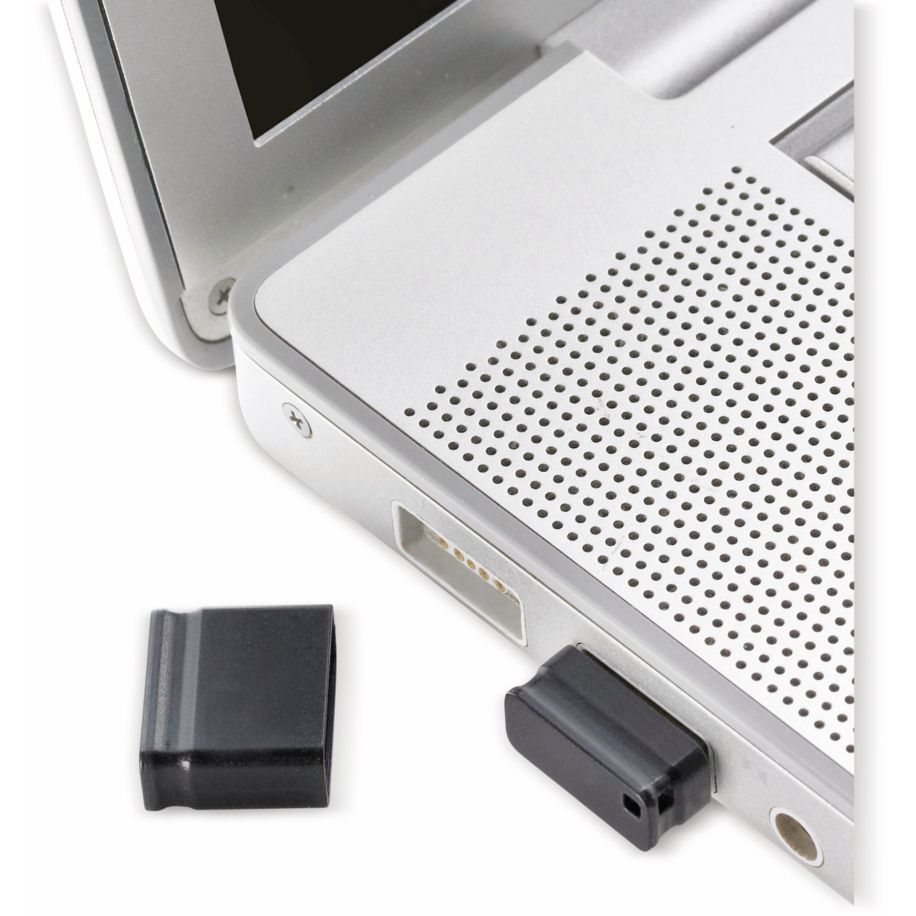 Srebrny laptop z włożonym czarnym pendrivem, obok druga zaślepka. Białe tło.