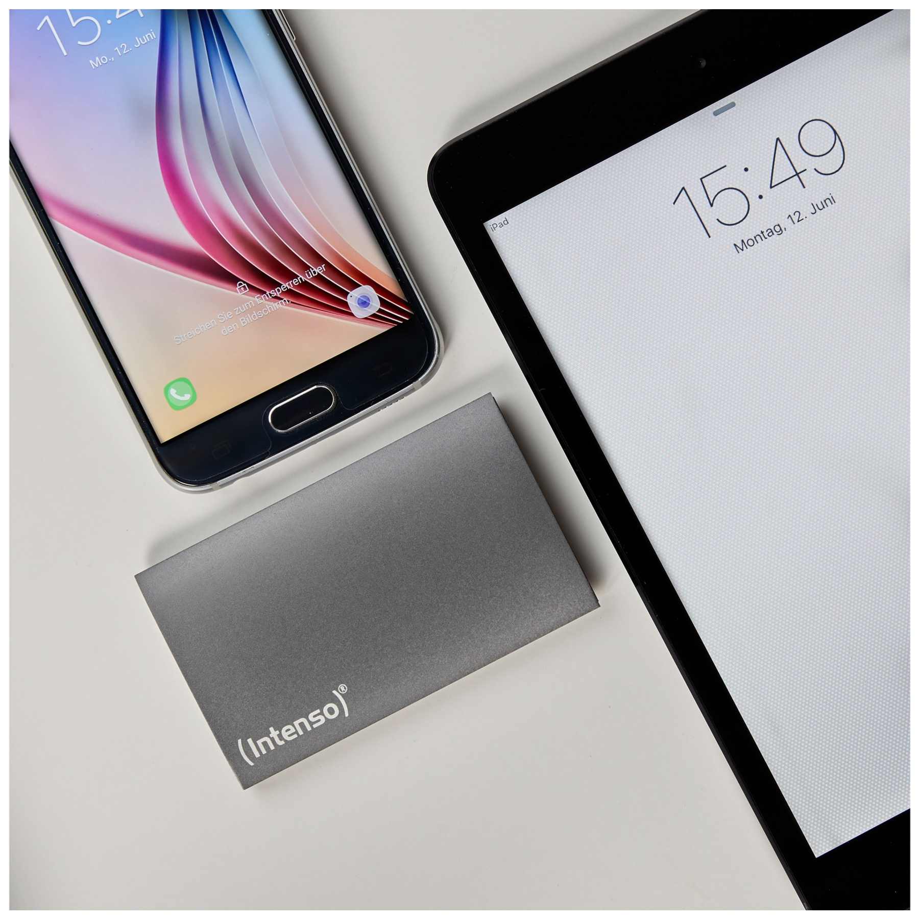 Smartfon i iPad na białej powierzchni. Szary prostokąt z napisem 'Intenso' pomiędzy nimi.