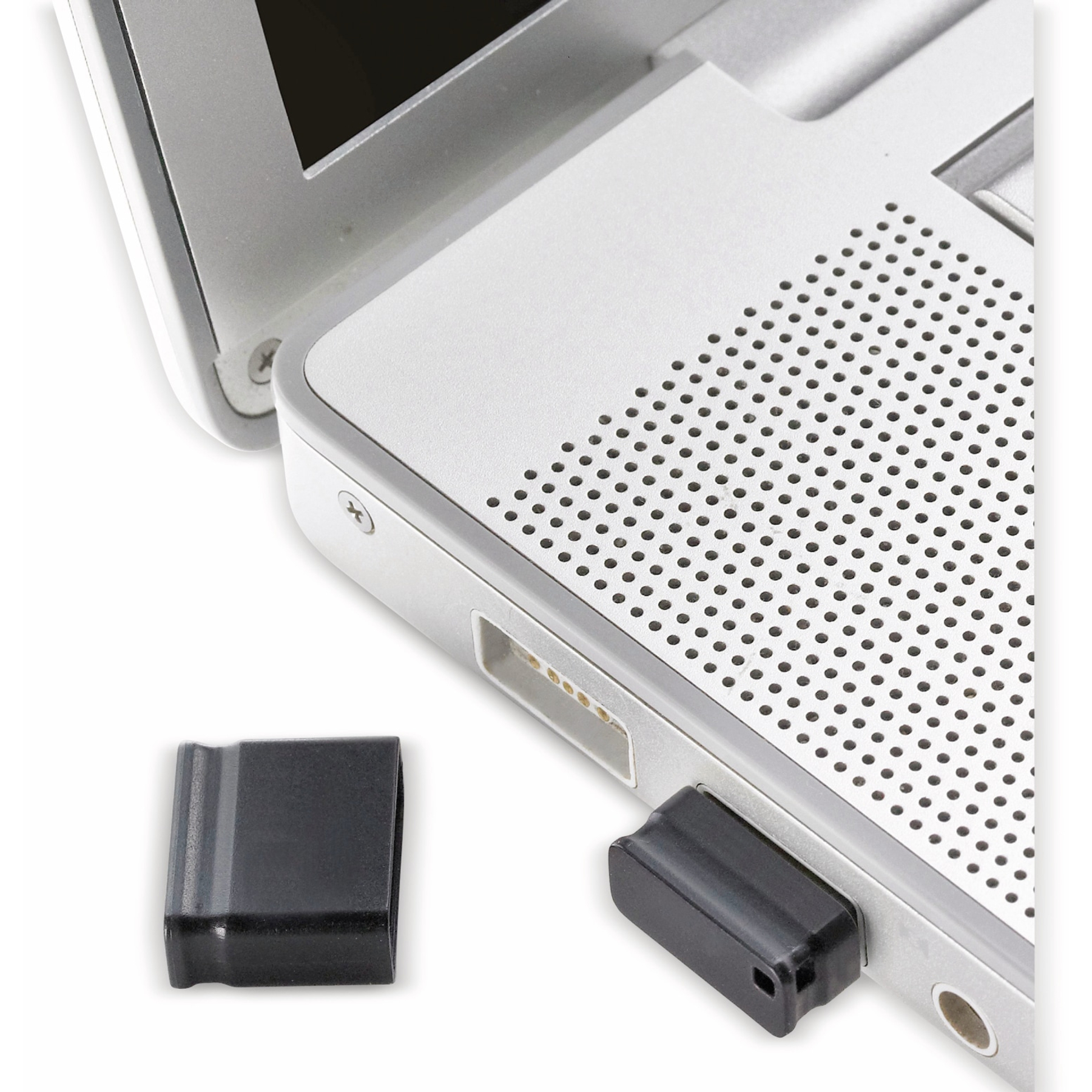 Laptop z czarną nasadką USB włożoną i drugą odłączoną. Laptop jest srebrny.