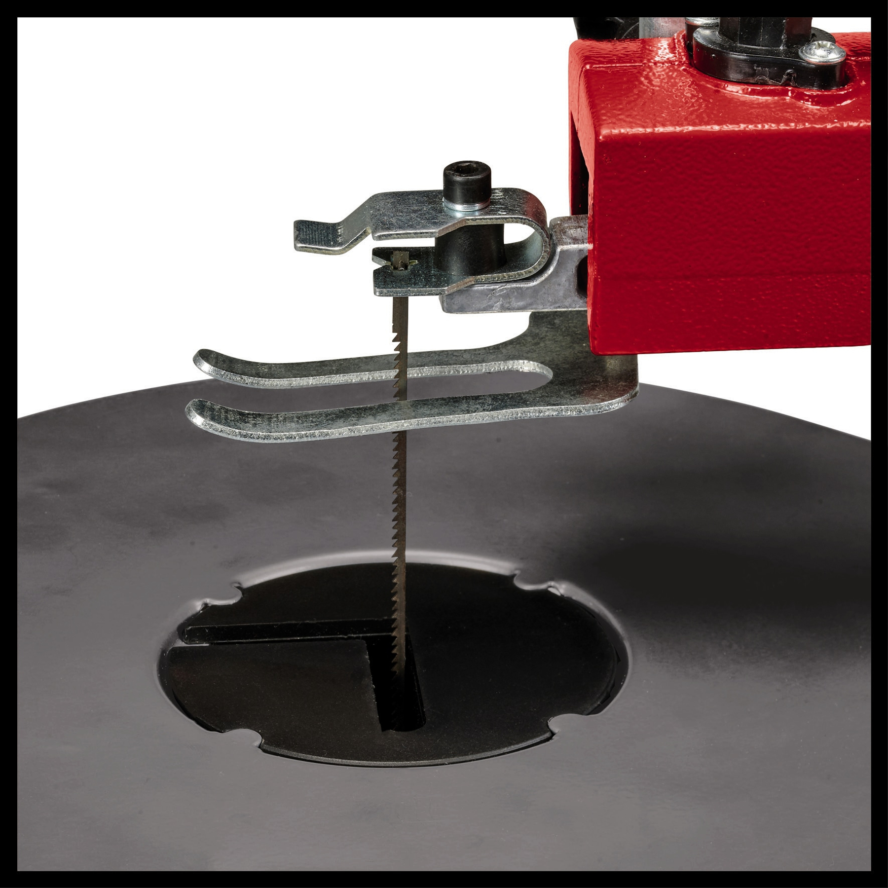 Czerwona wyrzynarka z czarną podstawą. Ostrze znajduje się między ramieniem a podstawą. Wyrzynarka na białym tle.