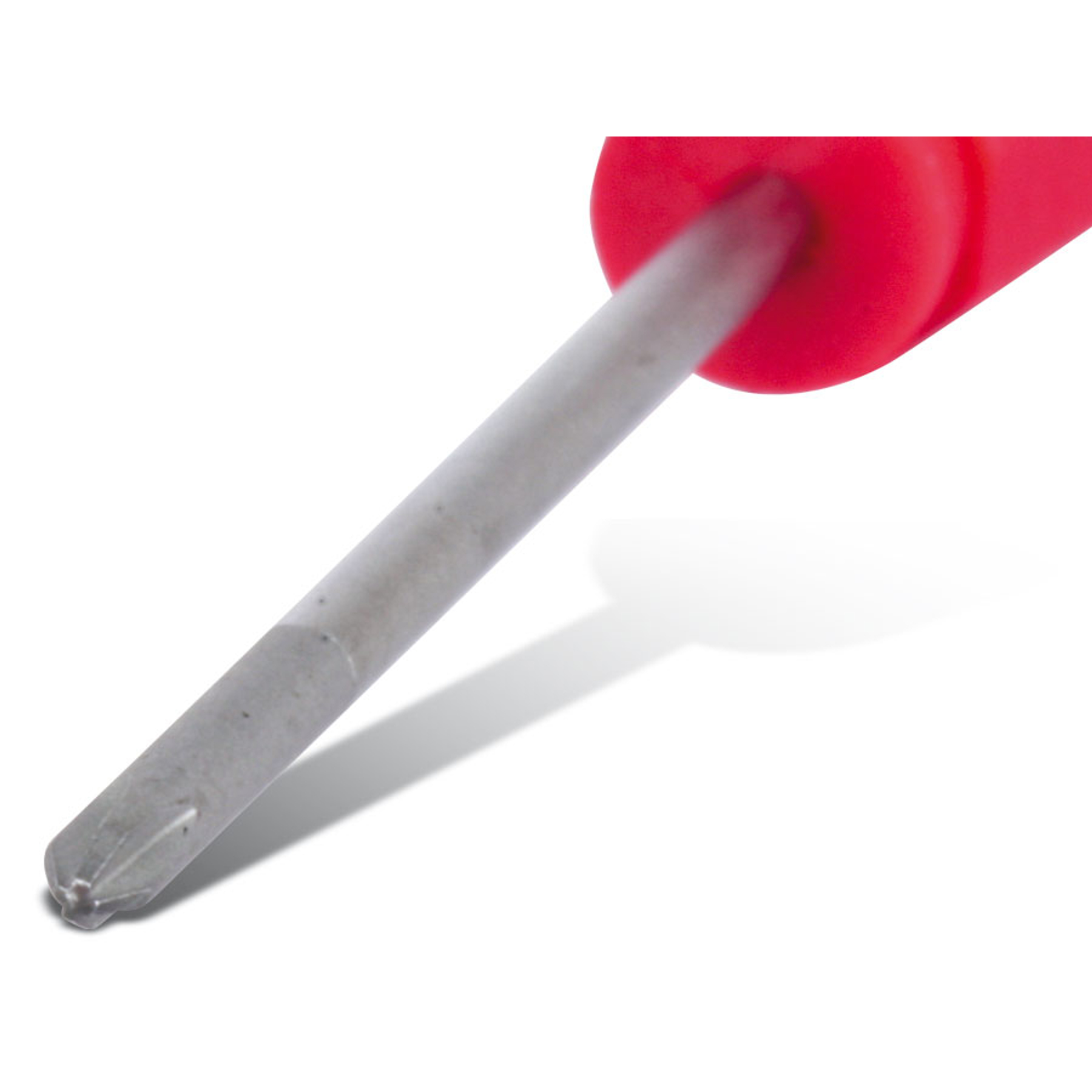 Zbliżenie śrubokręta. Rękojeść czerwona, metalowy trzon szary. Narzędzie rzuca cień na białą powierzchnię.