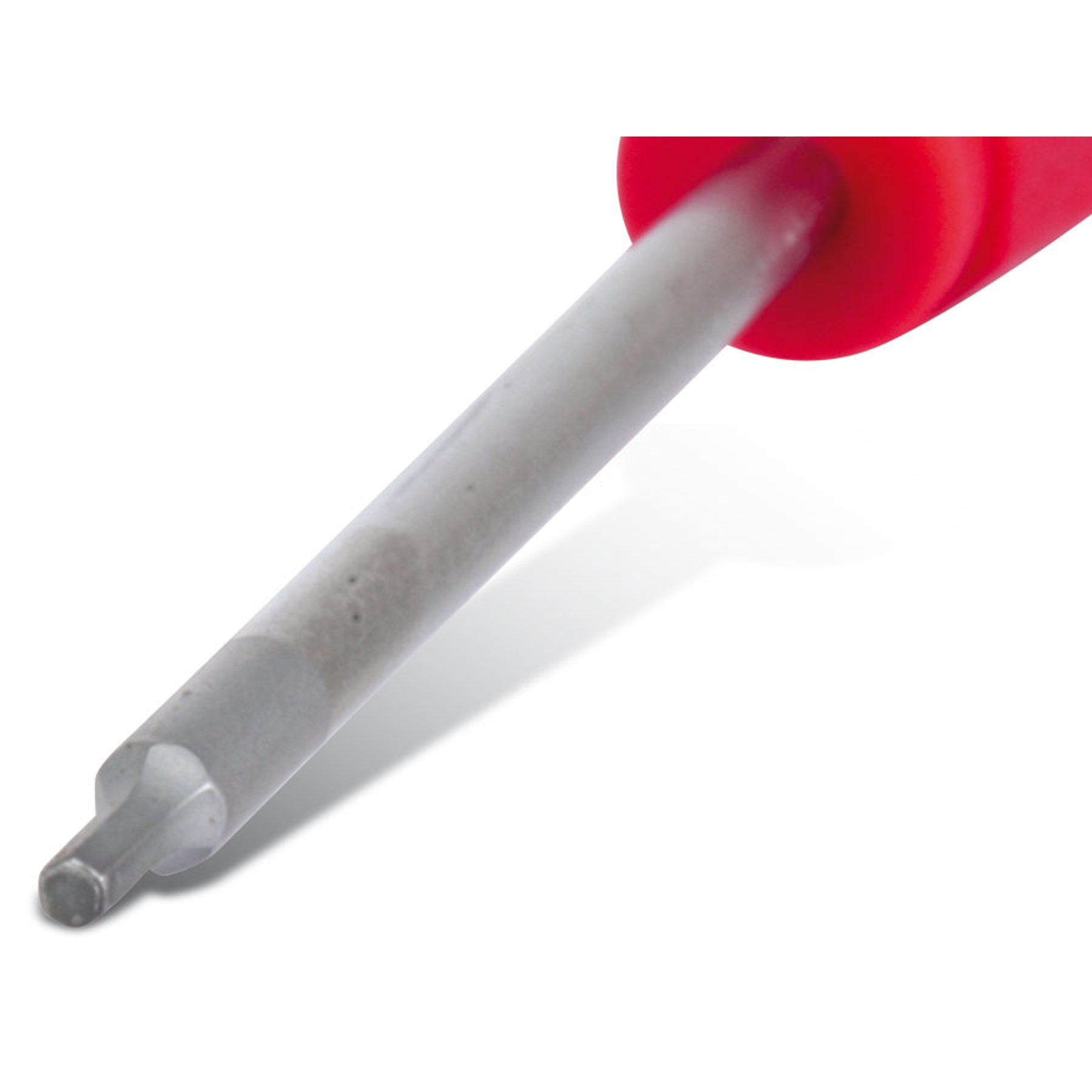 Zbliżenie śrubokręta. Rękojeść jest czerwona, a metalowy trzon szary i skierowany w lewo w dół.